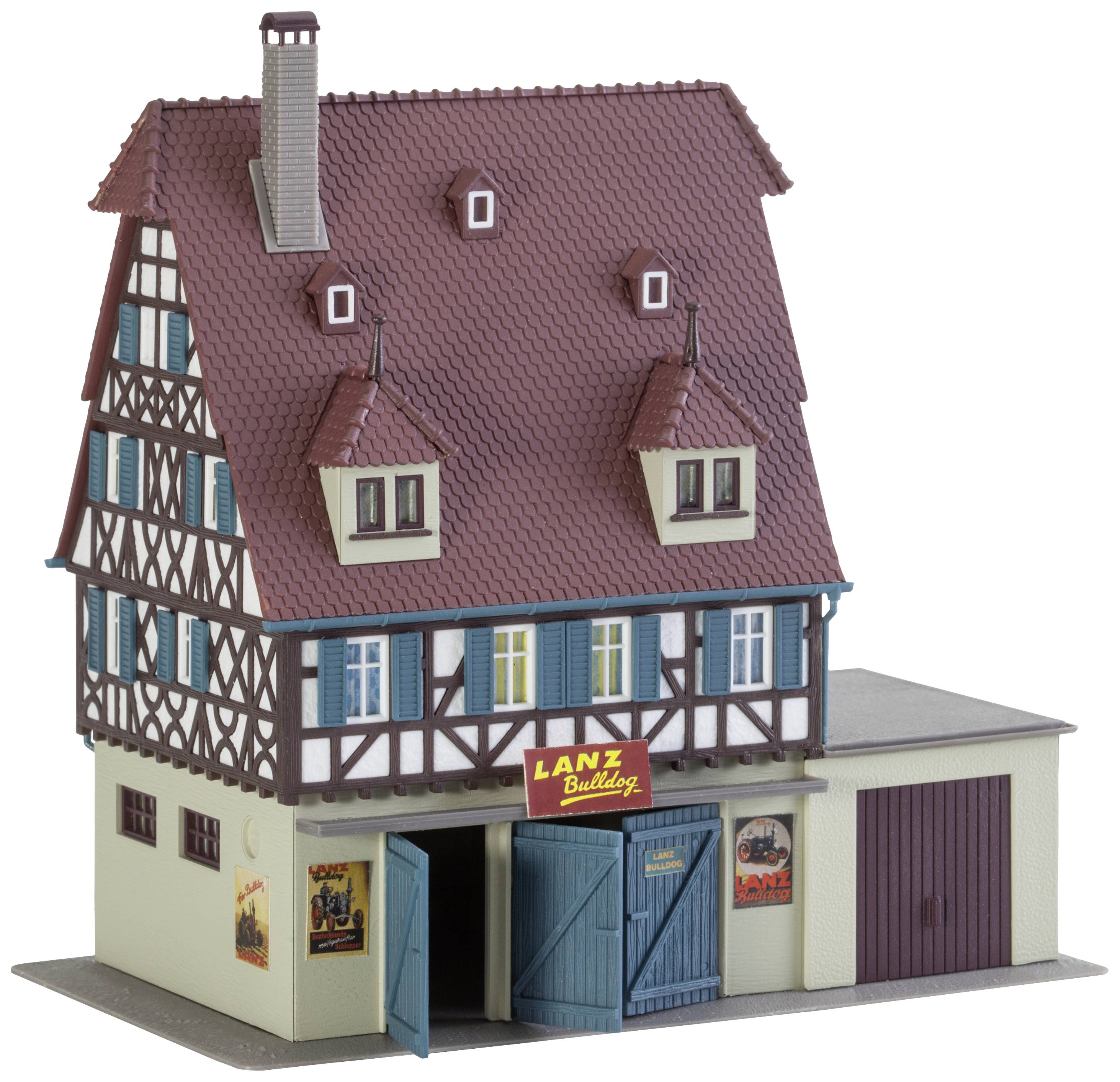 Una casa modello in stile a graticcio con tetto marrone e diverse finestre. Al piano terra si trova un garage con il cartello 'Lanz Bulldog'.