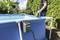 Una grande piscina rettangolare blu all'aperto. Una persona tiene una pompa sopra la piscina. In primo piano è montata una pompa Metabo.