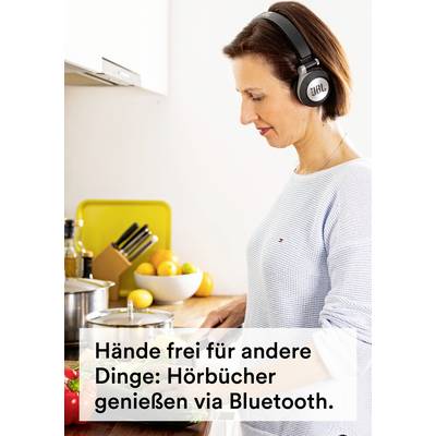 Donna in cucina che cucina e ascolta audiolibri con le cuffie. Testo nell'immagine: 'Mani libere per altre cose: goditi gli audiolibri tramite Bluetooth.'