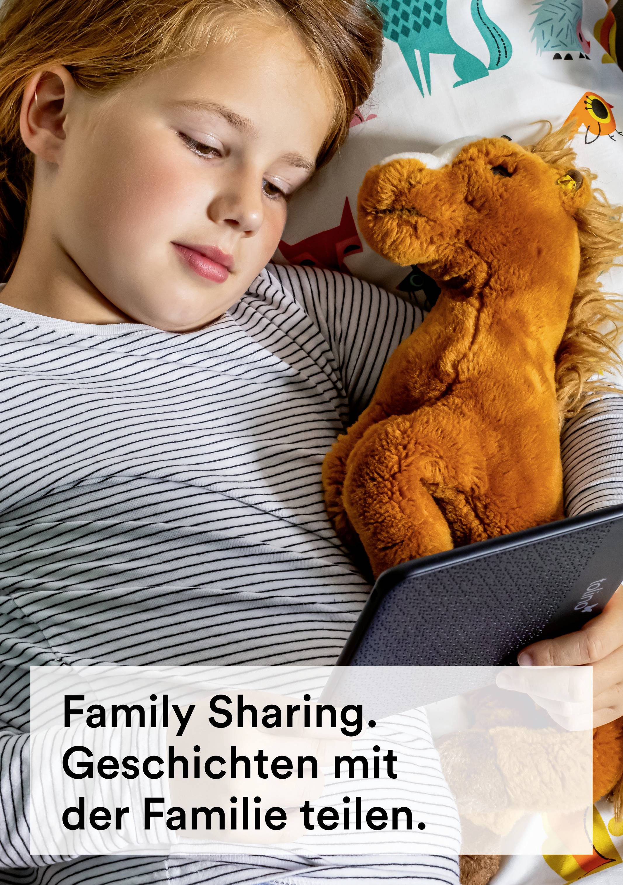 Un bambino è sdraiato a letto con un peluche e sta leggendo su un e-reader. Testo sull'immagine: 'Condivisione Familiare. Condividi le storie con la famiglia.'