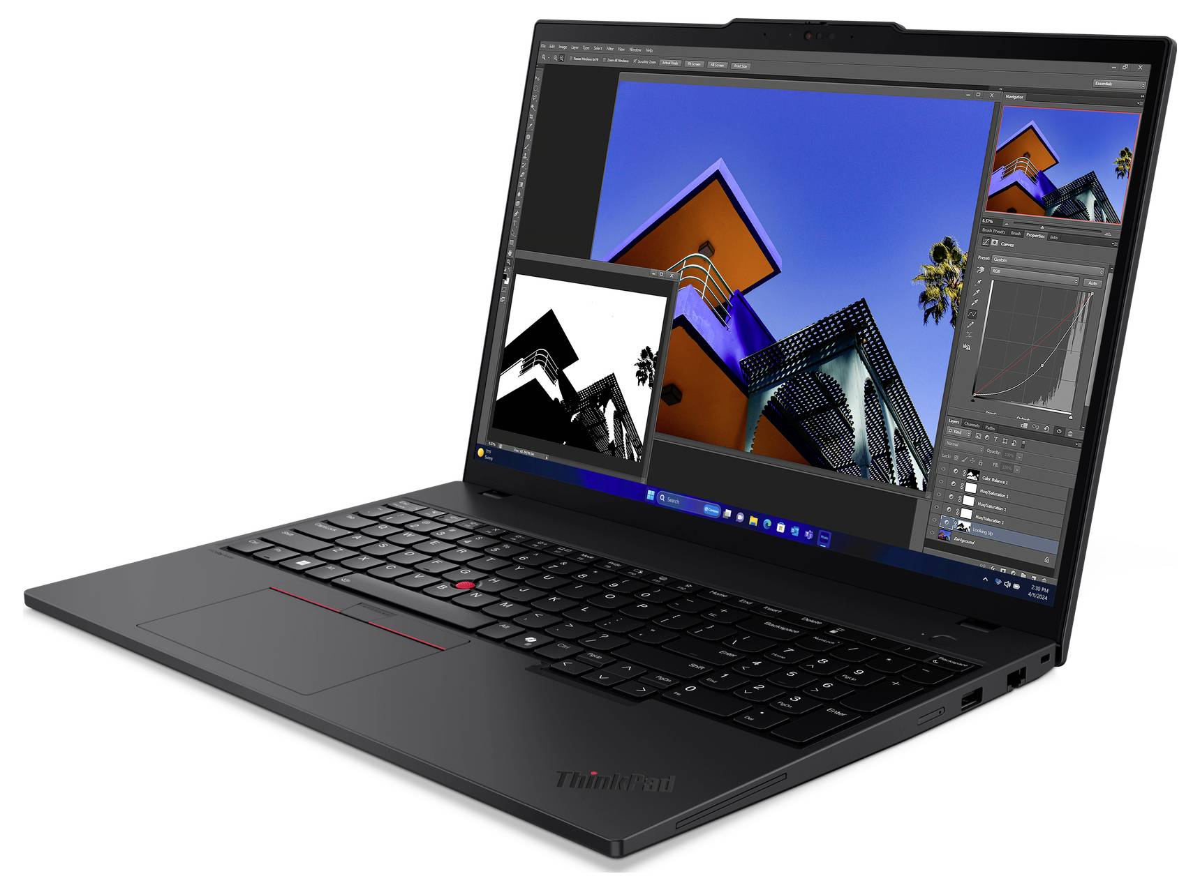 Un laptop aperto mostra un programma di elaborazione immagini con foto di architettura moderna sullo schermo.