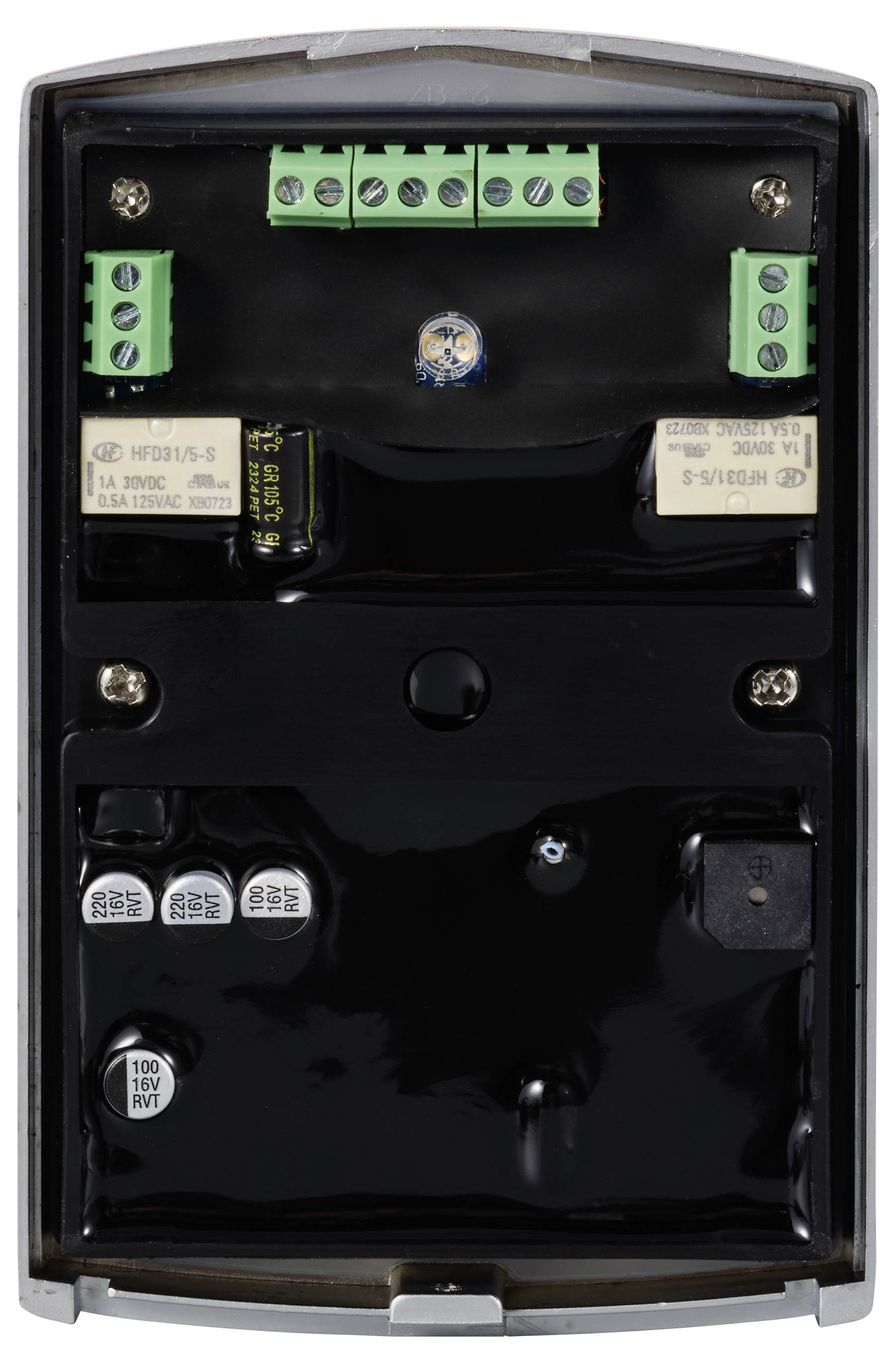 Un dispositivo elettronico aperto con diversi morsetti verdi e componenti nere su un circuito stampato nero, disposti strettamente.