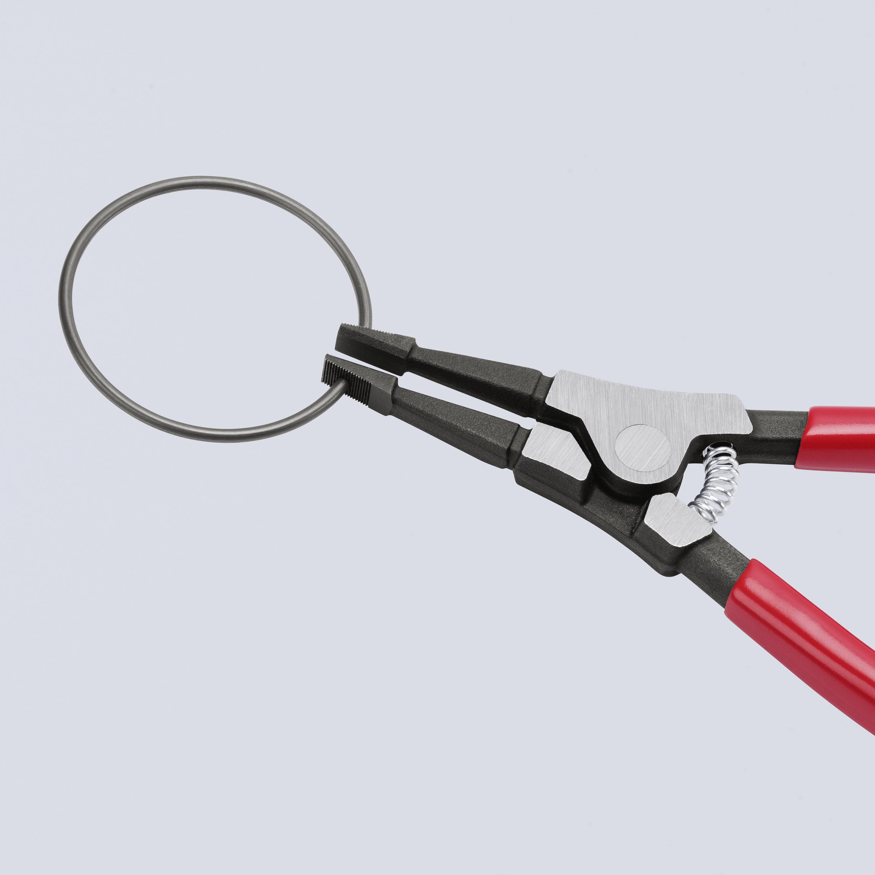 Una pinza tiene un anello metallico. La pinza ha impugnature rosse ed è mostrata in posizione aperta. Lo sfondo è azzurro chiaro.