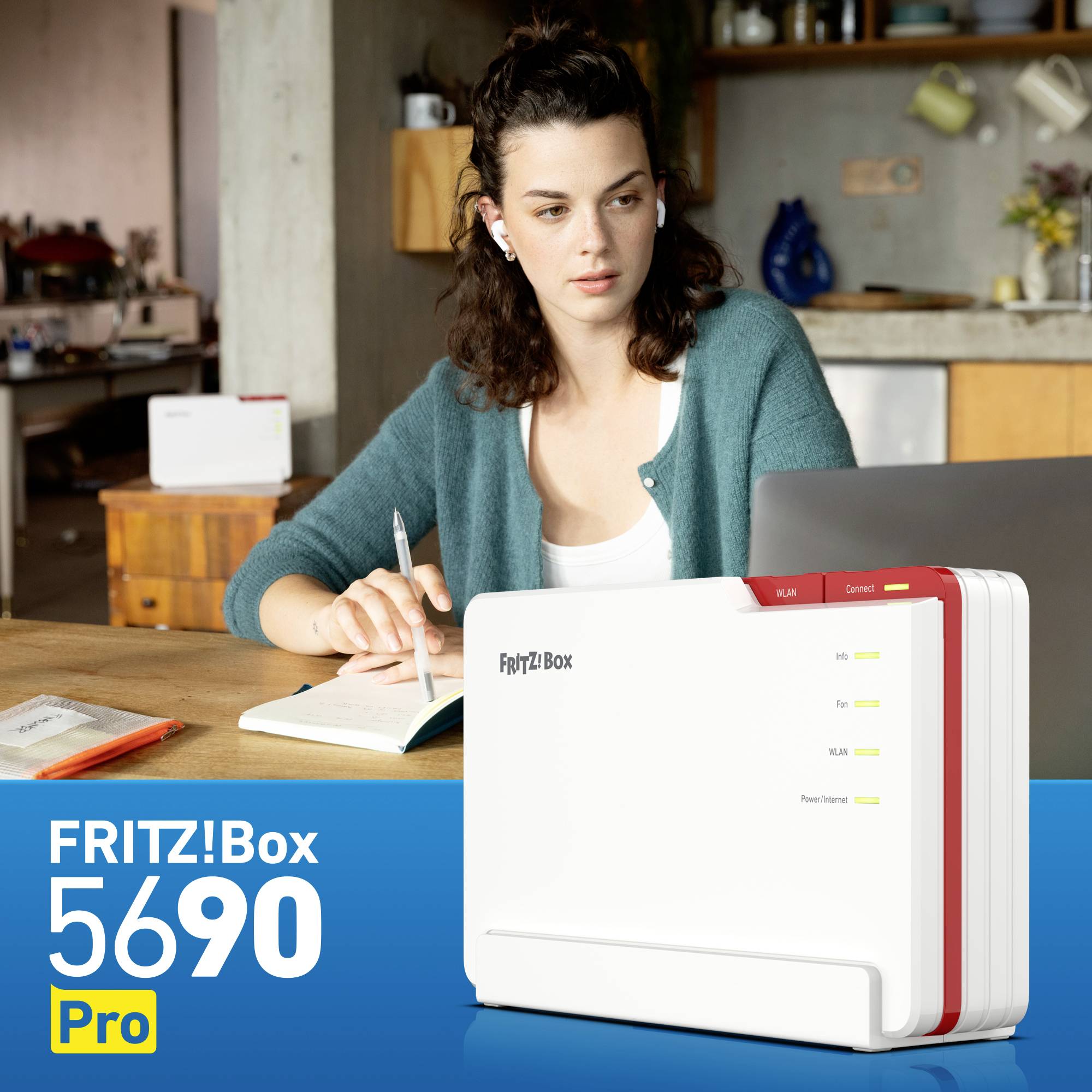 Una donna è seduta al tavolo e sta scrivendo appunti. In primo piano è raffigurata una FRITZ!Box 5690 Pro.