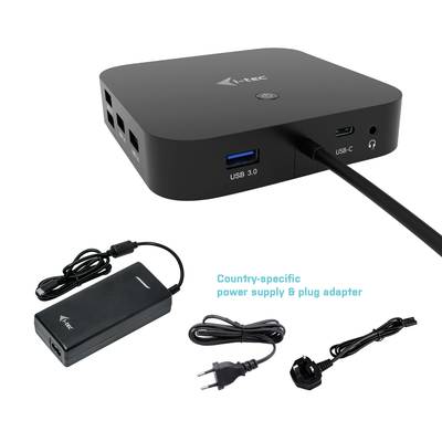 Un hub USB nero e rettangolare con diversi porte è posizionato accanto a un alimentatore e un adattatore.