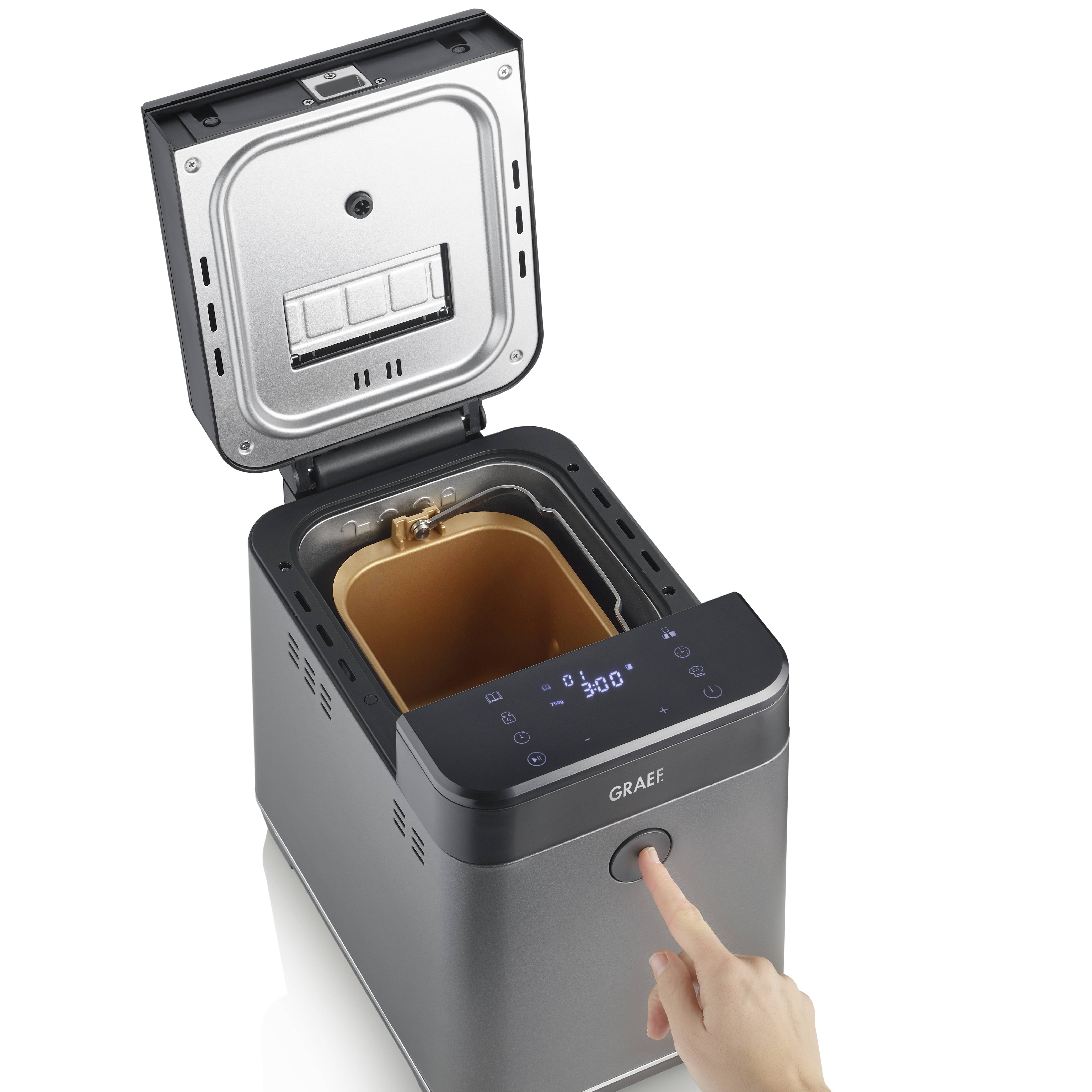 'Macchina per il pane con coperchio aperto. Una mano indica il pannello di controllo digitale con un display che mostra 3:00 ore.'