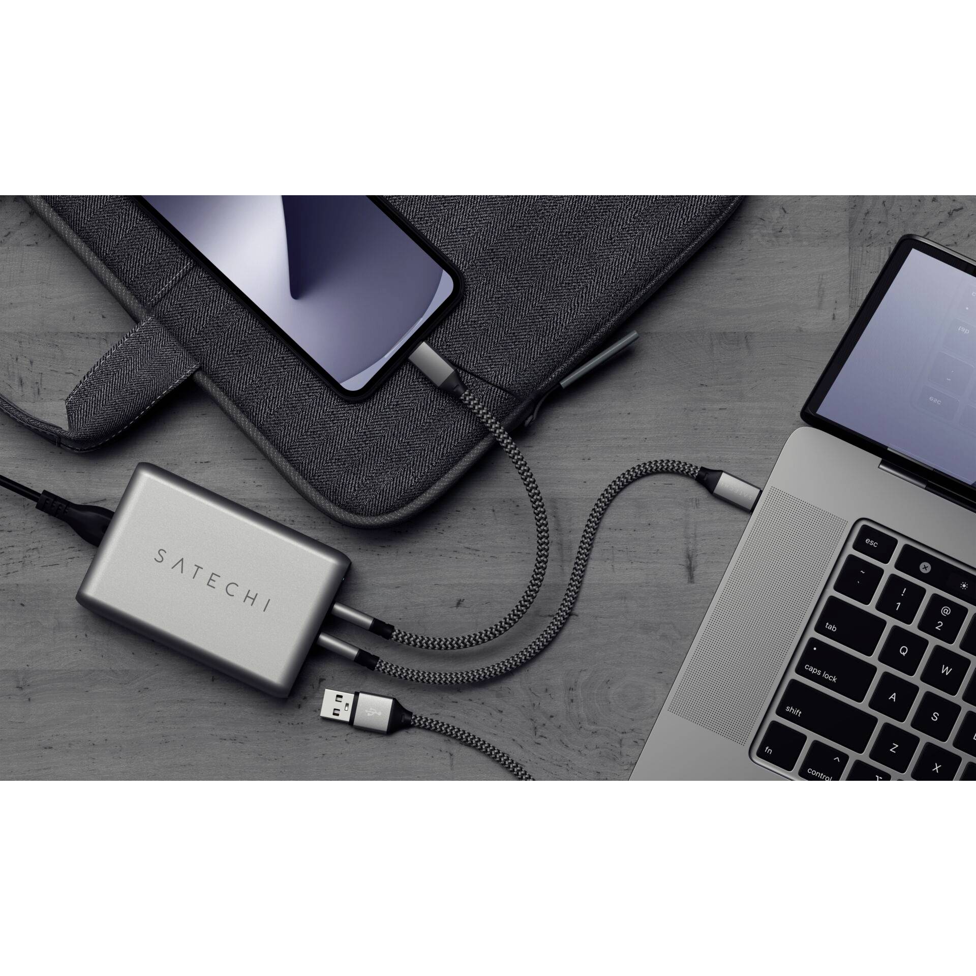 Un smartphone e un laptop sono collegati a un hub USB-C. L'hub ha diversi porte, ideale per una connettività versatile.