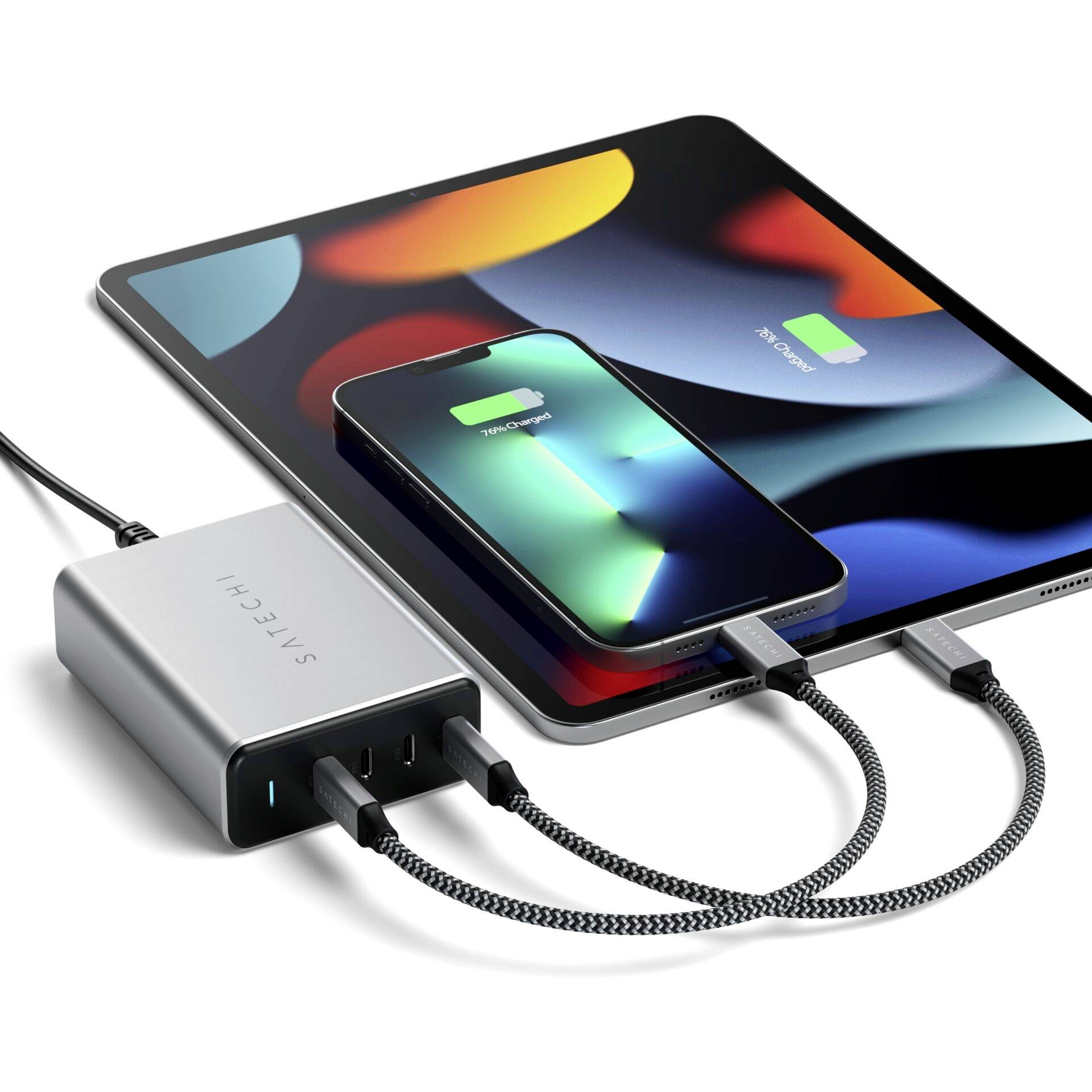 Un caricabatterie con tre porte sta caricando contemporaneamente un tablet e uno smartphone. Entrambi i dispositivi mostrano la schermata di ricarica.
