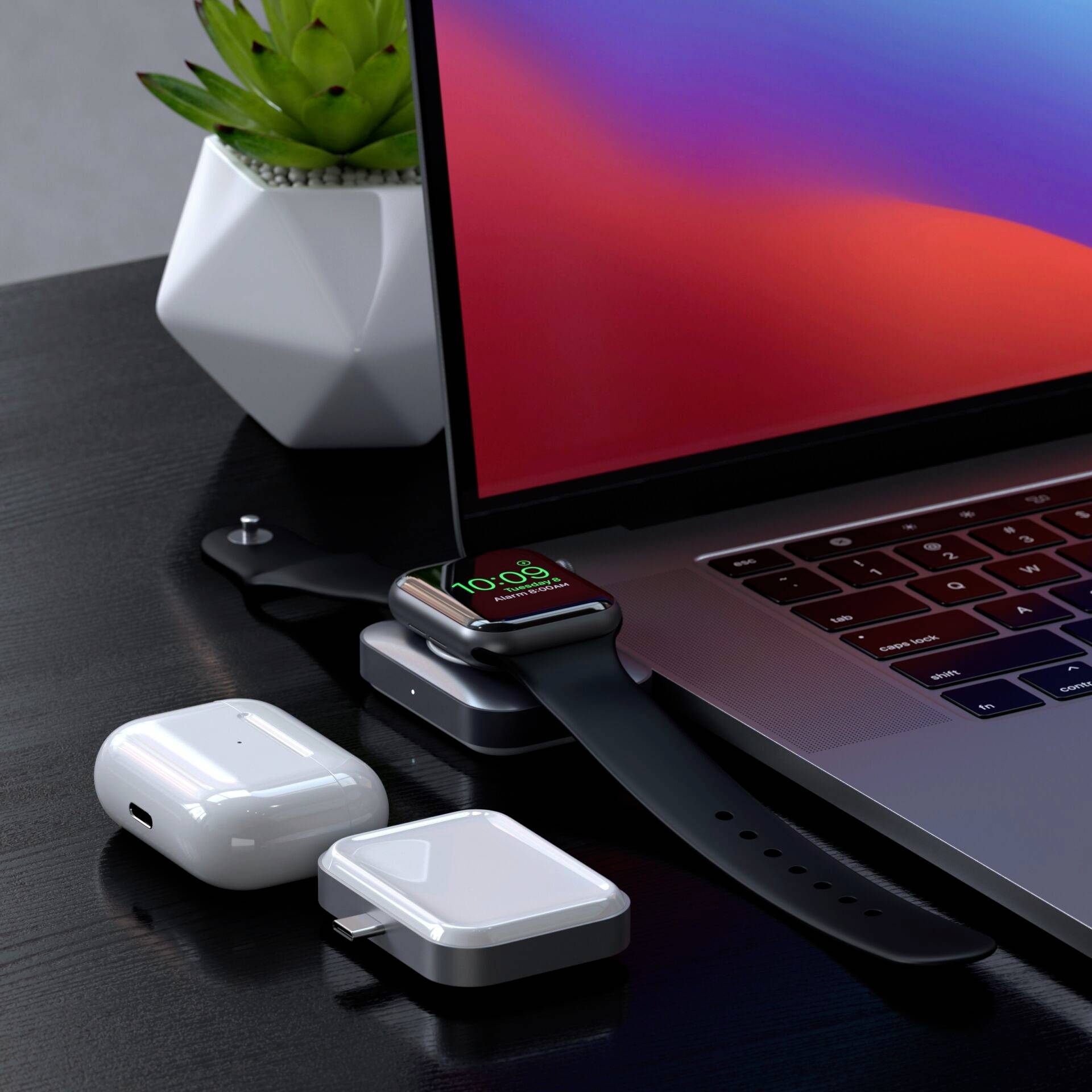 Sul tavolo ci sono un laptop, uno smartwatch, degli auricolari wireless e accessori per la ricarica. L'orologio segna '10:09'.