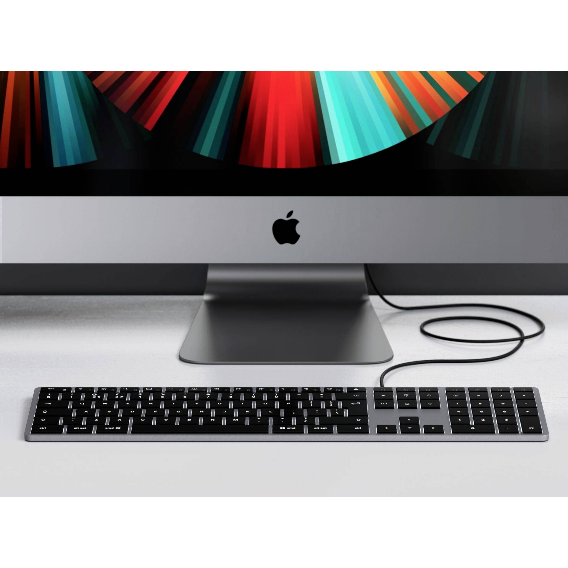 Un computer moderno con un grande schermo su cui vengono visualizzate grafiche astratte luminose. Una tastiera è posizionata davanti su un tavolo.