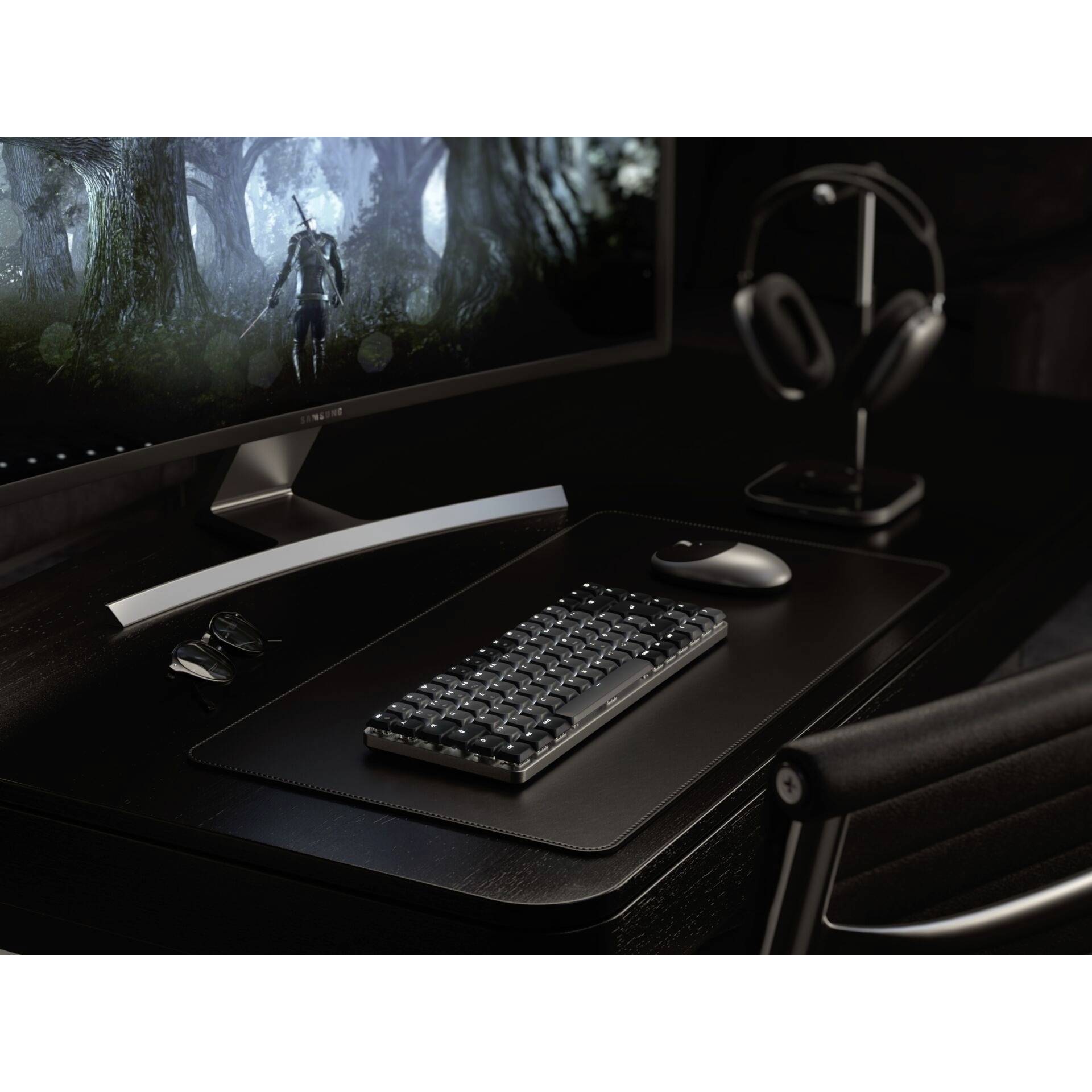 Scrivania con schermo del computer che mostra un gioco di fantasia. Tastiera, mouse, cuffie e occhiali sul tavolo. Ambiente scuro e moderno.