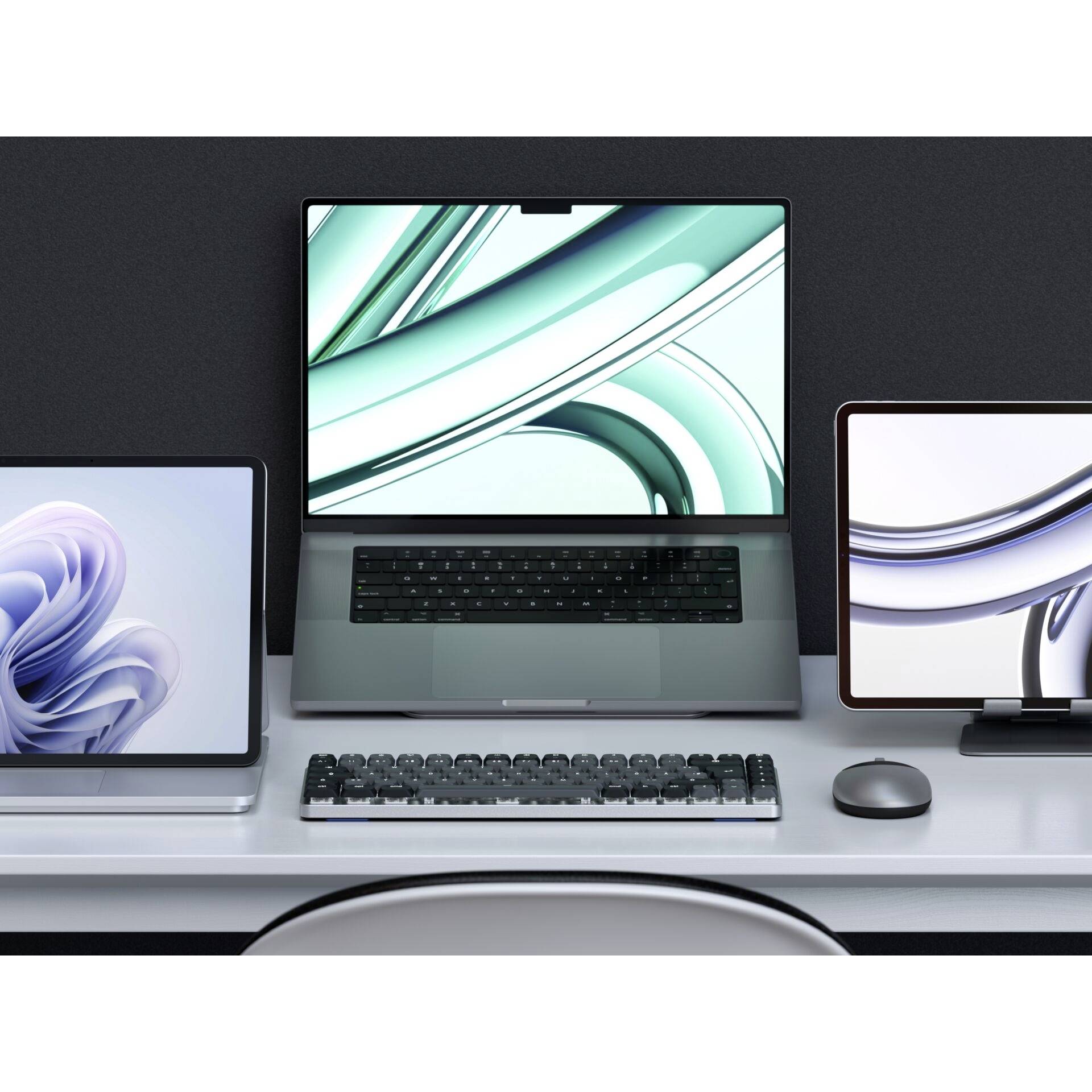 Tre schermi su una scrivania mostrano grafiche digitali astratte, attrezzati con tastiera e mouse. Arredamento ufficio moderno.