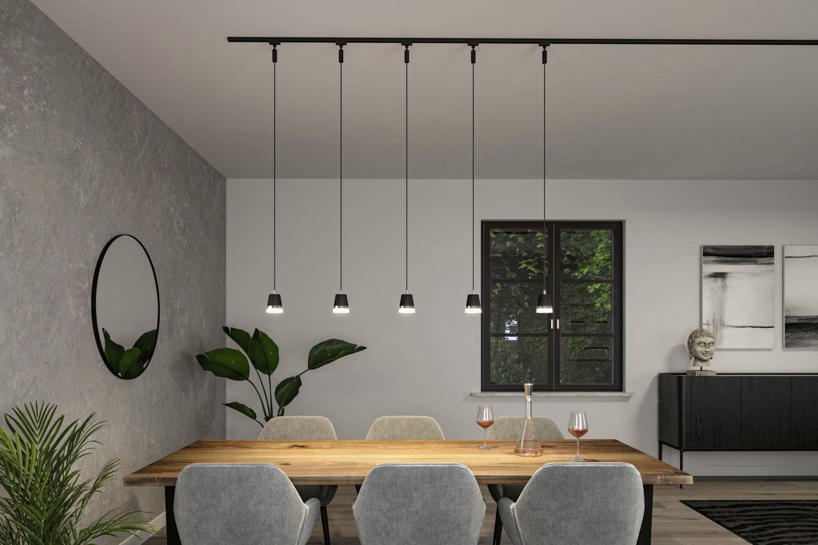 Sala da pranzo con tavolo in legno, sei sedie grigie, cinque lampade a sospensione, uno specchio sulla parete e alcune piante nella stanza.