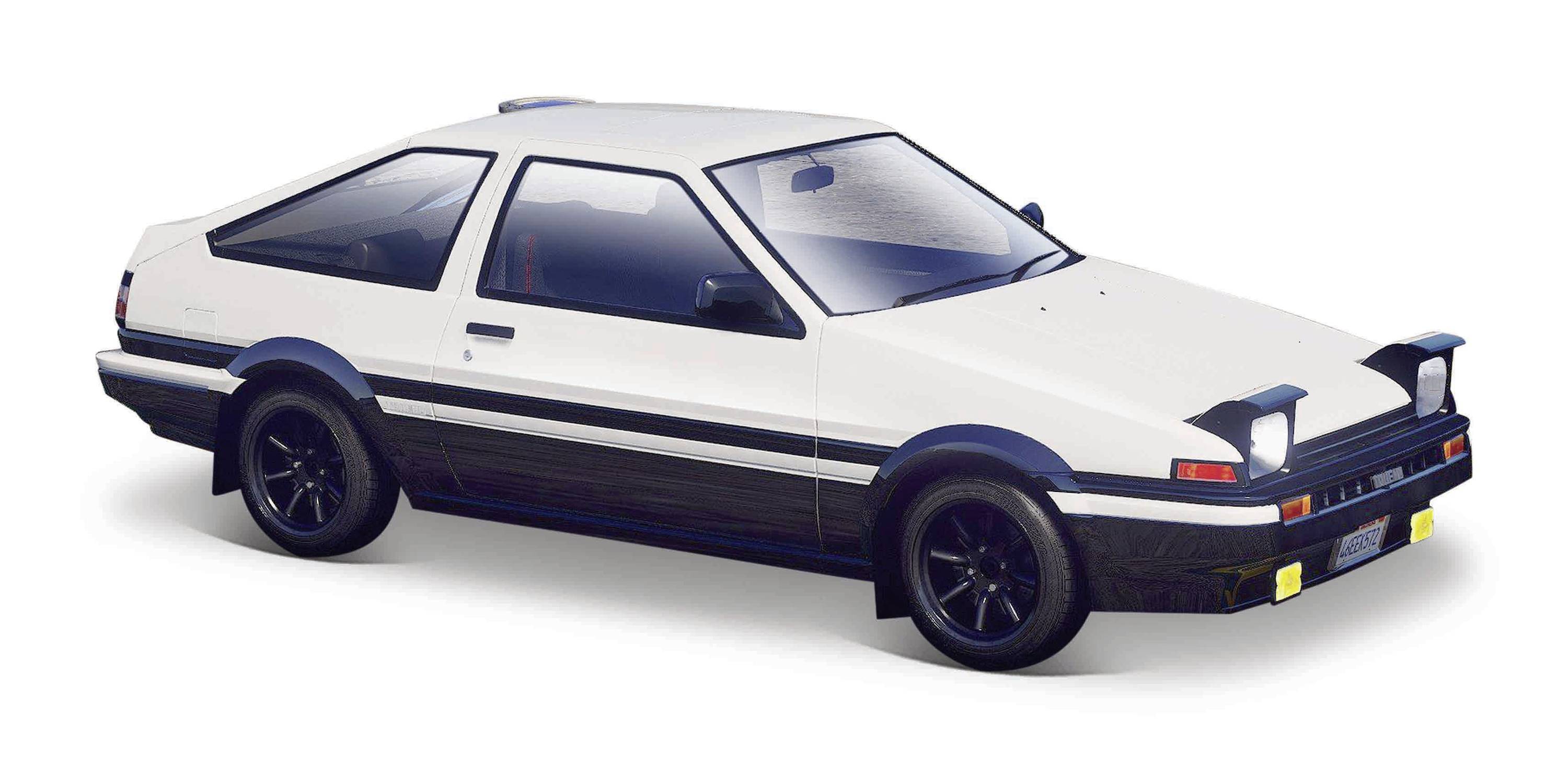 Un coupé sportivo bianco e nero con i fari aperti è parcheggiato di lato, mostrando un design sportivo e una linea classica.