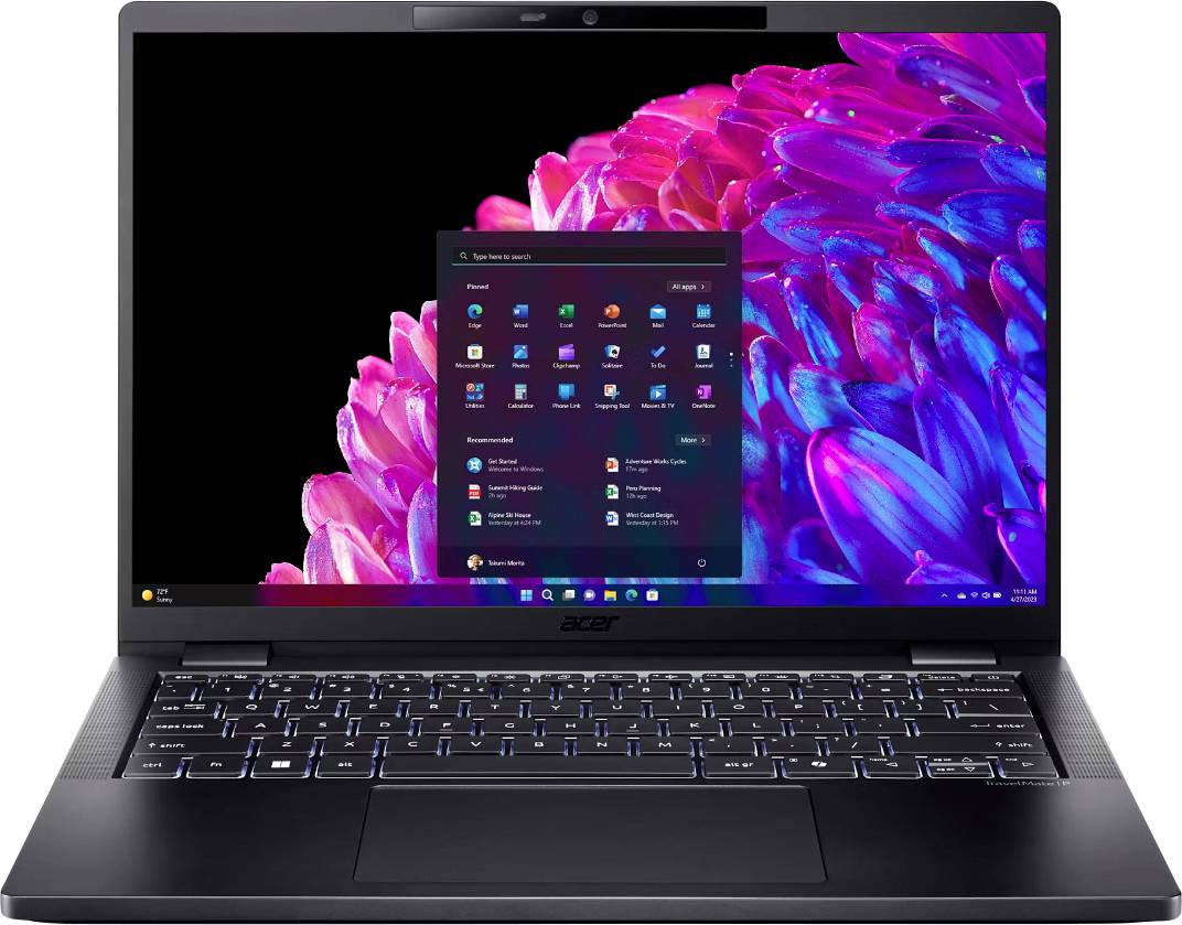 Un laptop aperto con schermo illuminato. Sullo schermo è visibile il menu di avvio di Windows. Sullo sfondo, un motivo variopinto di fiori.