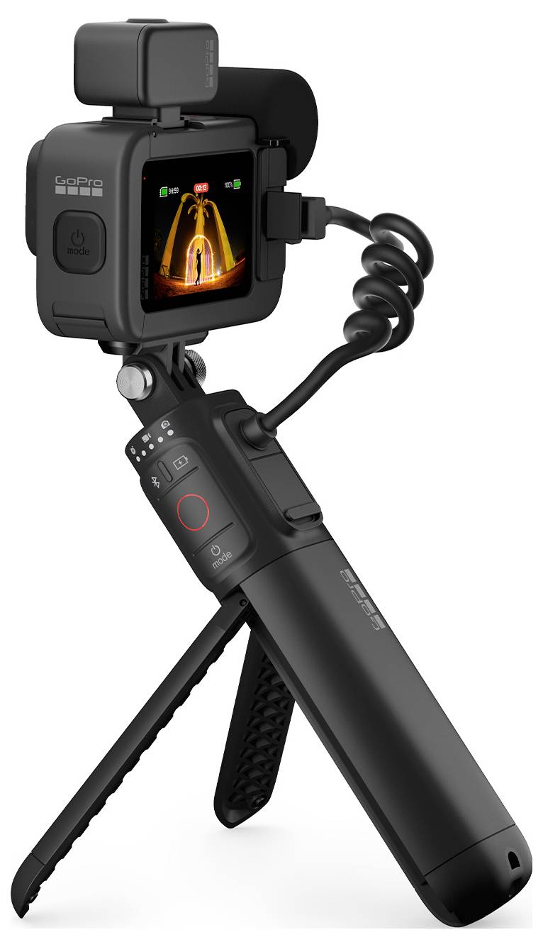 Una fotocamera nera portatile con schermo mostra un soggetto con effetti di luce arancioni. La fotocamera è posizionata su un treppiede pieghevole.