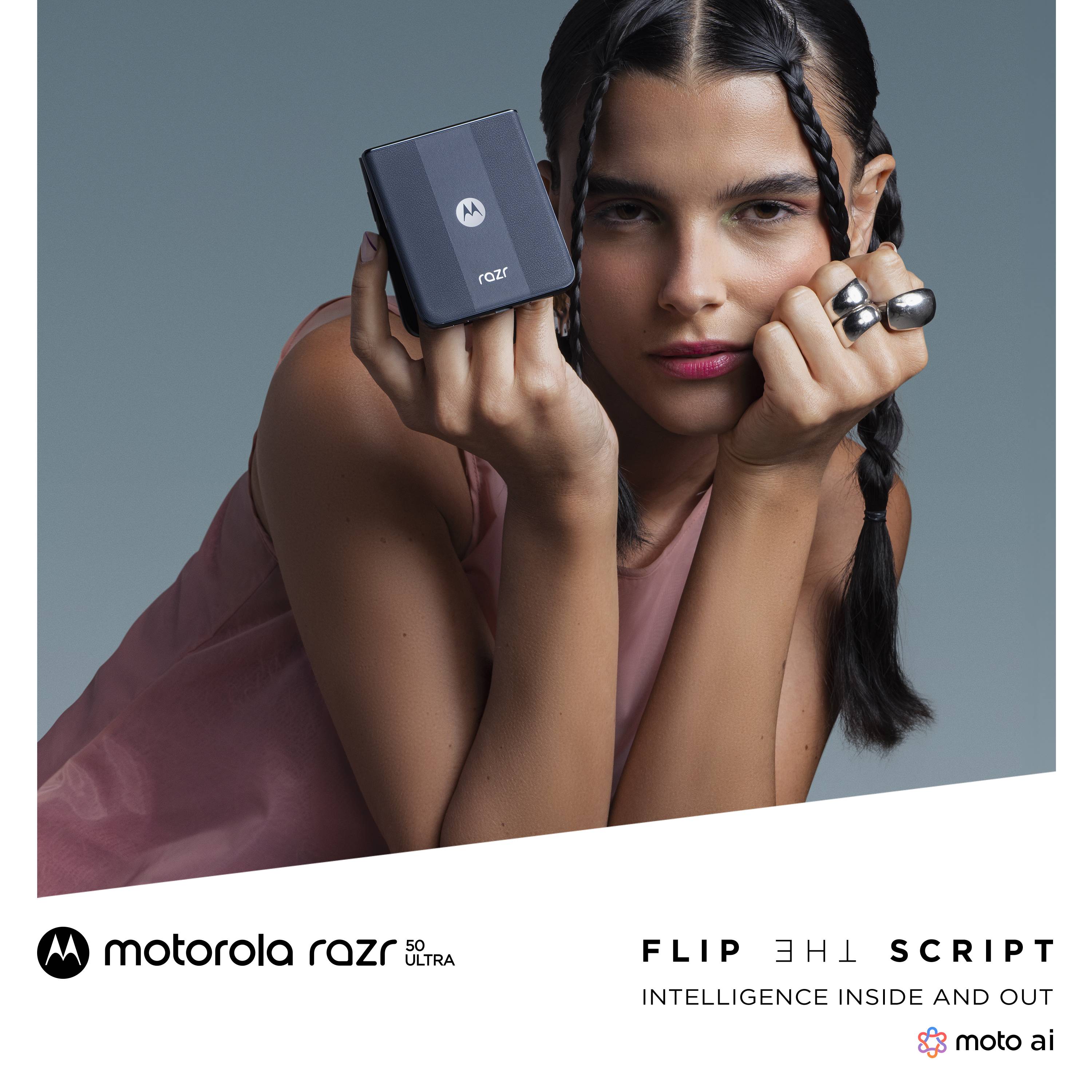 Una persona tiene in mano uno smartphone pieghevole compatto. Sull'immagine è scritto 'Flip the Script – Intelligenza dentro e fuori'.