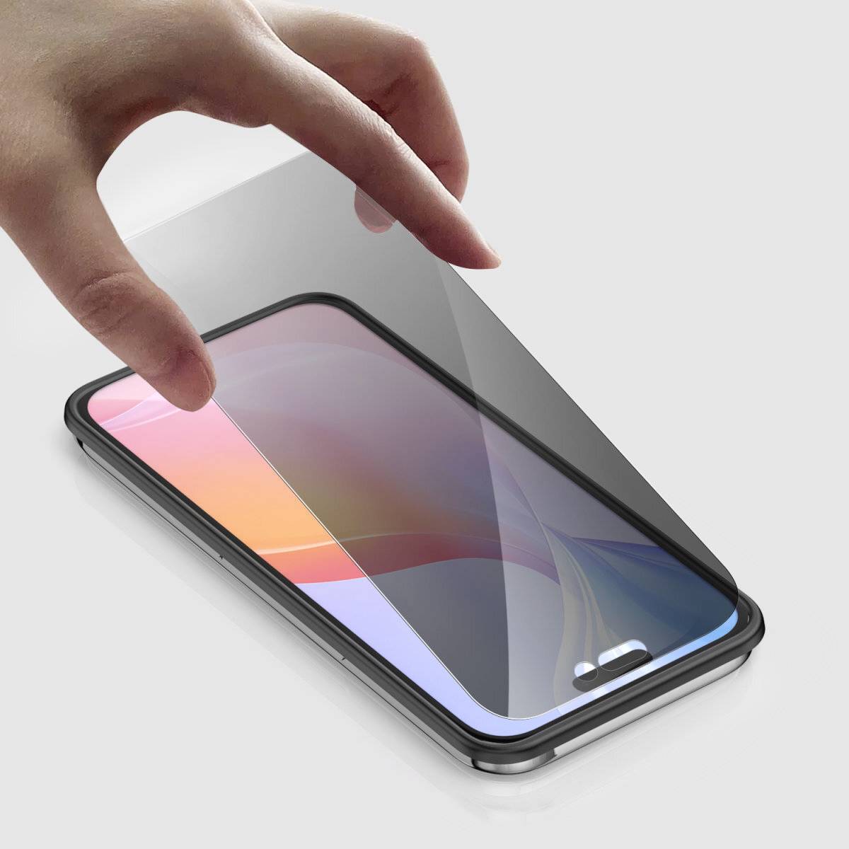 Una mano sta applicando una pellicola protettiva su uno schermo di smartphone.