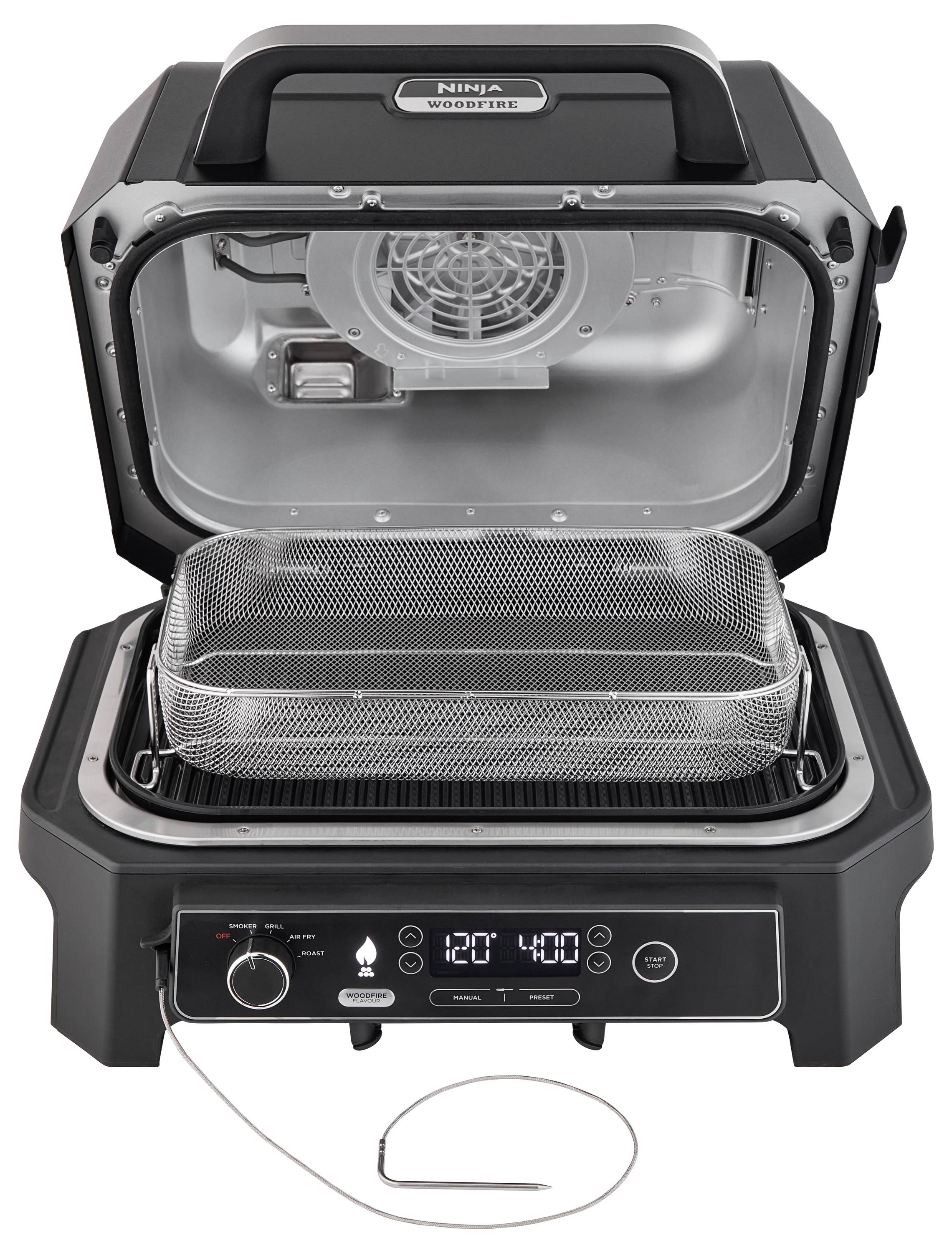 Un barbecue elettrico con coperchio aperto mostra un cestello rimovibile e un pannello di controllo con display di temperatura e timer.