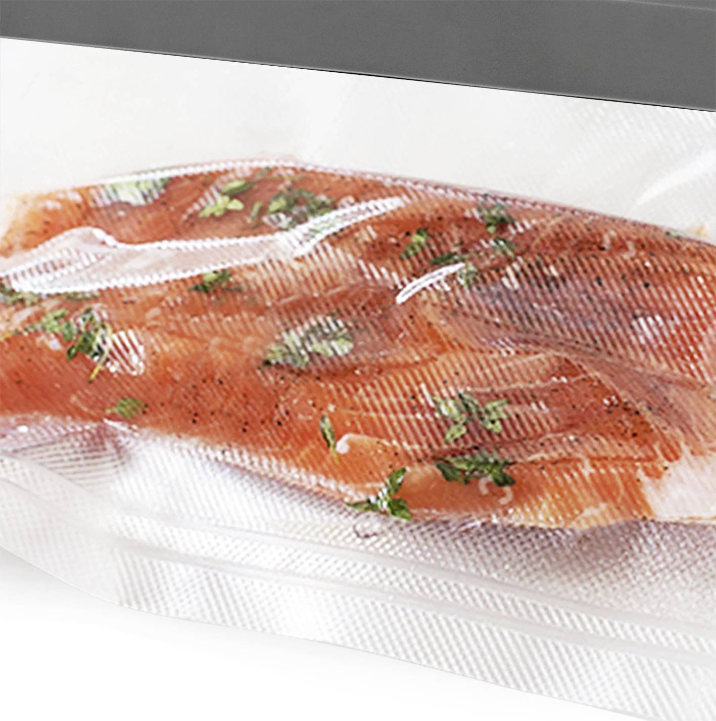 Un pezzo di salmone crudo, confezionato sottovuoto, condito con erbe e pepe, adagiato su una superficie bianca.