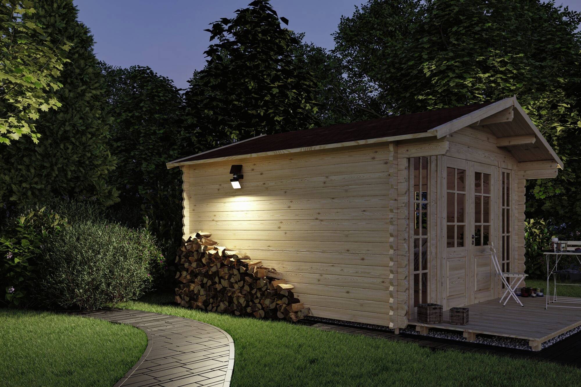 Una piccola casa di legno nel giardino al crepuscolo, con legna da ardere impilata sul lato e un ingresso illuminato.