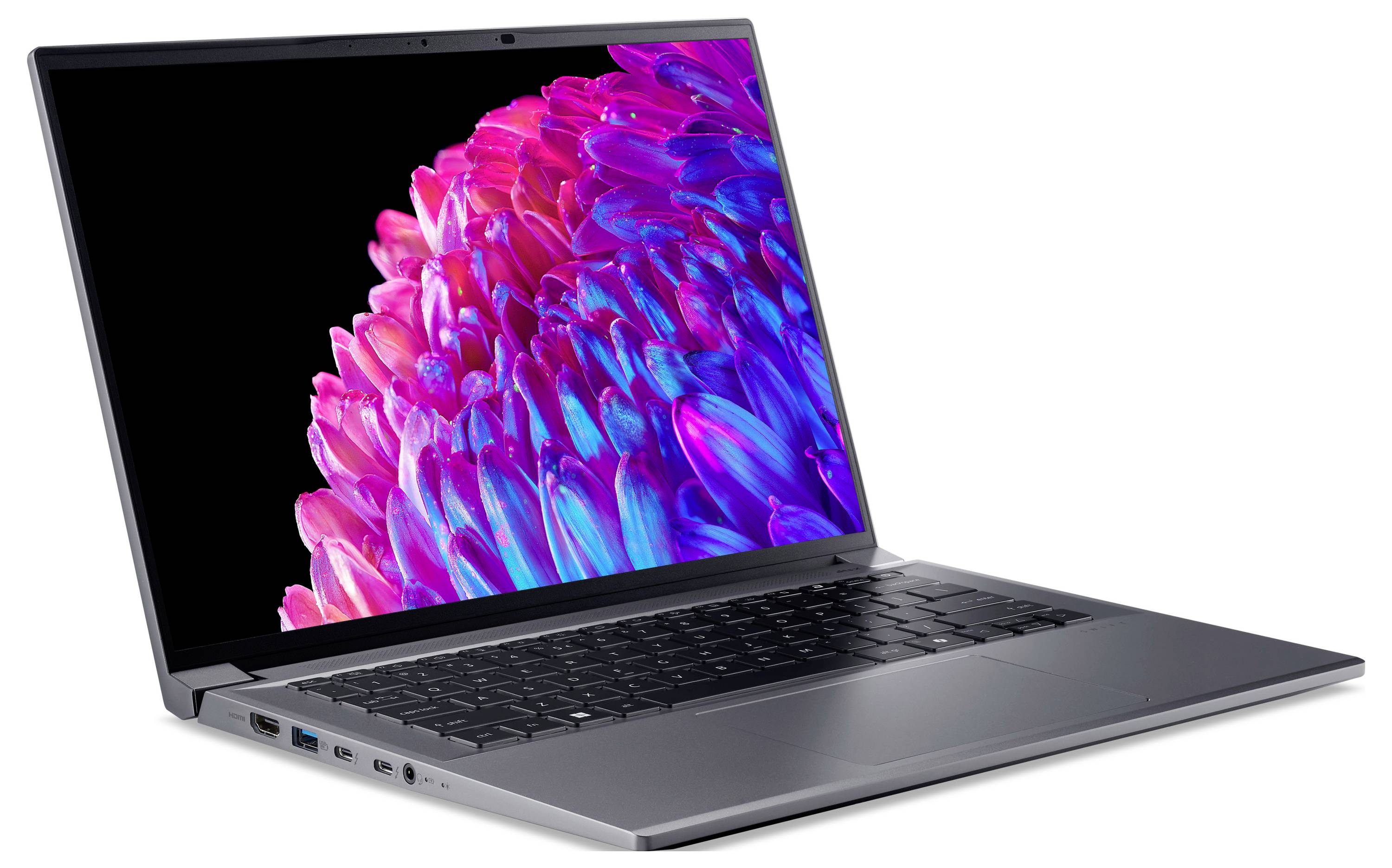 Un laptop con schermo aperto mostra un design astratto luminoso in tonalità di rosa e blu. Sono visibili la tastiera e le porte di connessione.