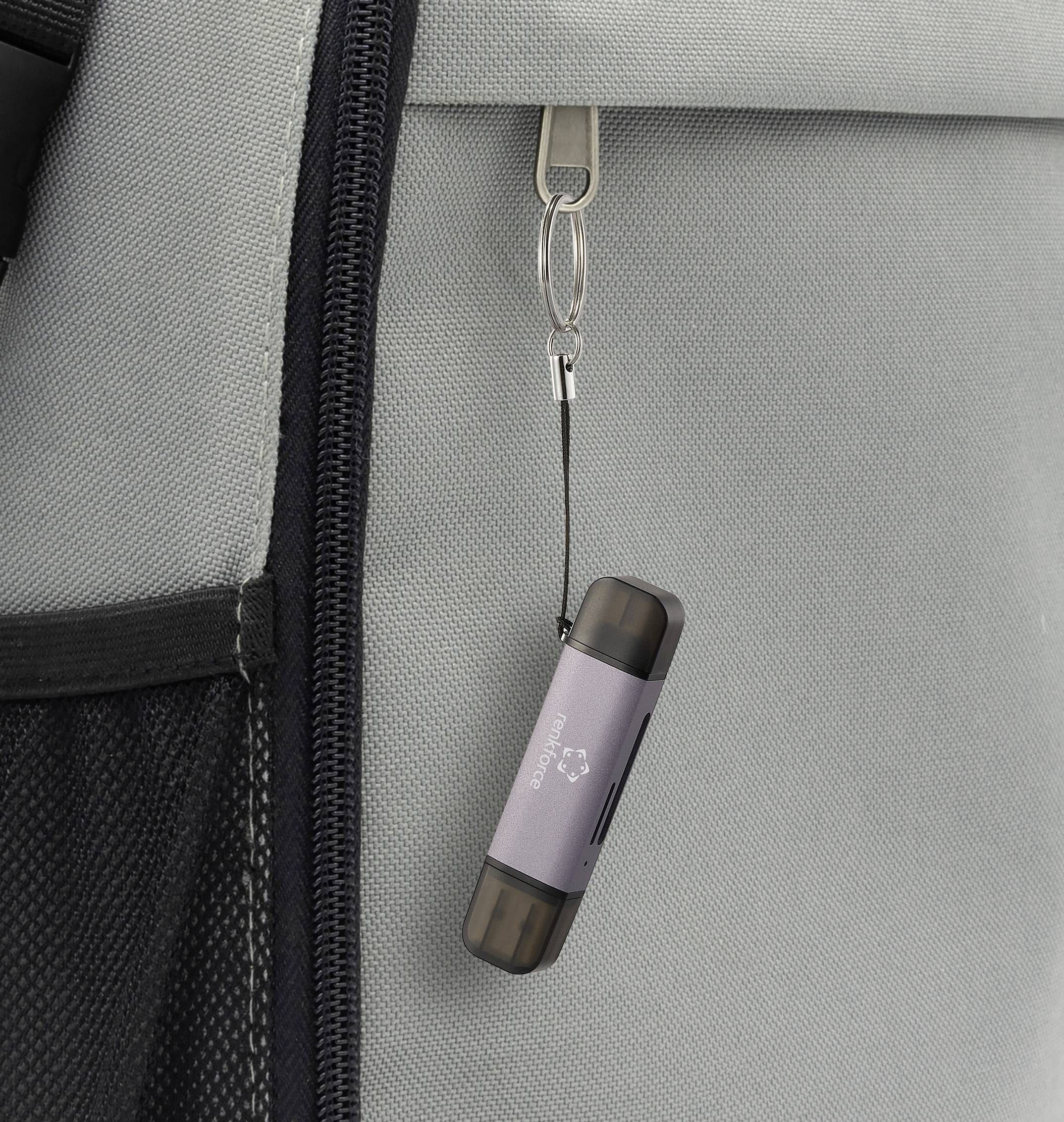 Una chiavetta USB è attaccata a uno zaino grigio.