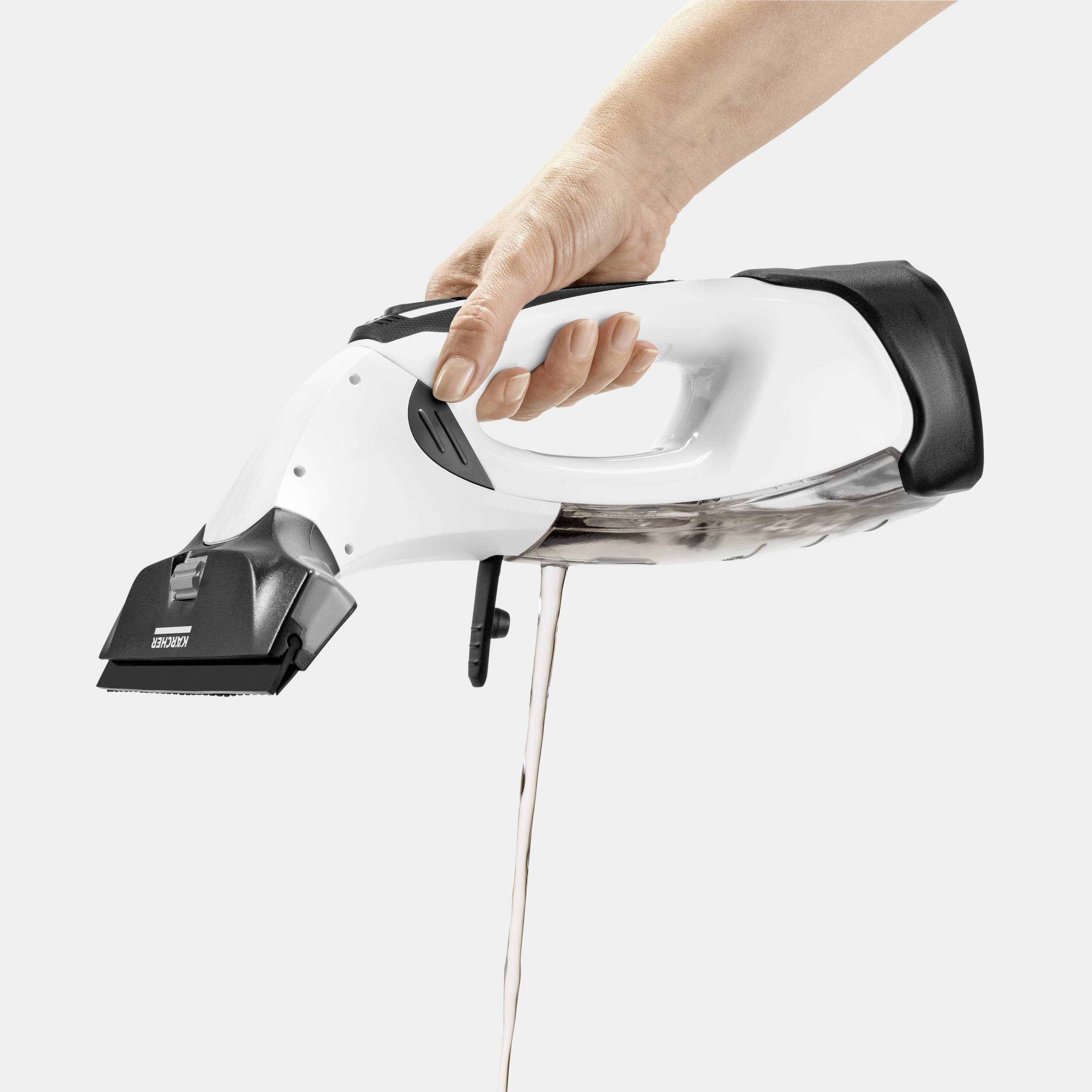Una mano tiene un aspirapolvere/aspiraliquidi bianco che scarica l'acqua attraverso l'ugello. Il dispositivo è compatto ed ergonomico.
