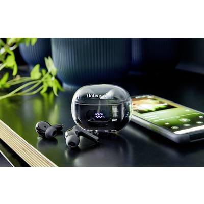 Cuffie wireless con custodia di ricarica trasparente e uno smartphone che riproduce musica. Le cuffie sono poggiate su un tavolo.