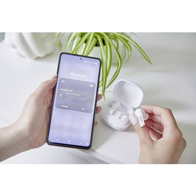 Una persona tiene uno smartphone con Bluetooth attivato, mostrando la connessione ai 'Hama Buds Pro'. La mano sinistra tiene un auricolare. Sullo sfondo è presente una pianta.