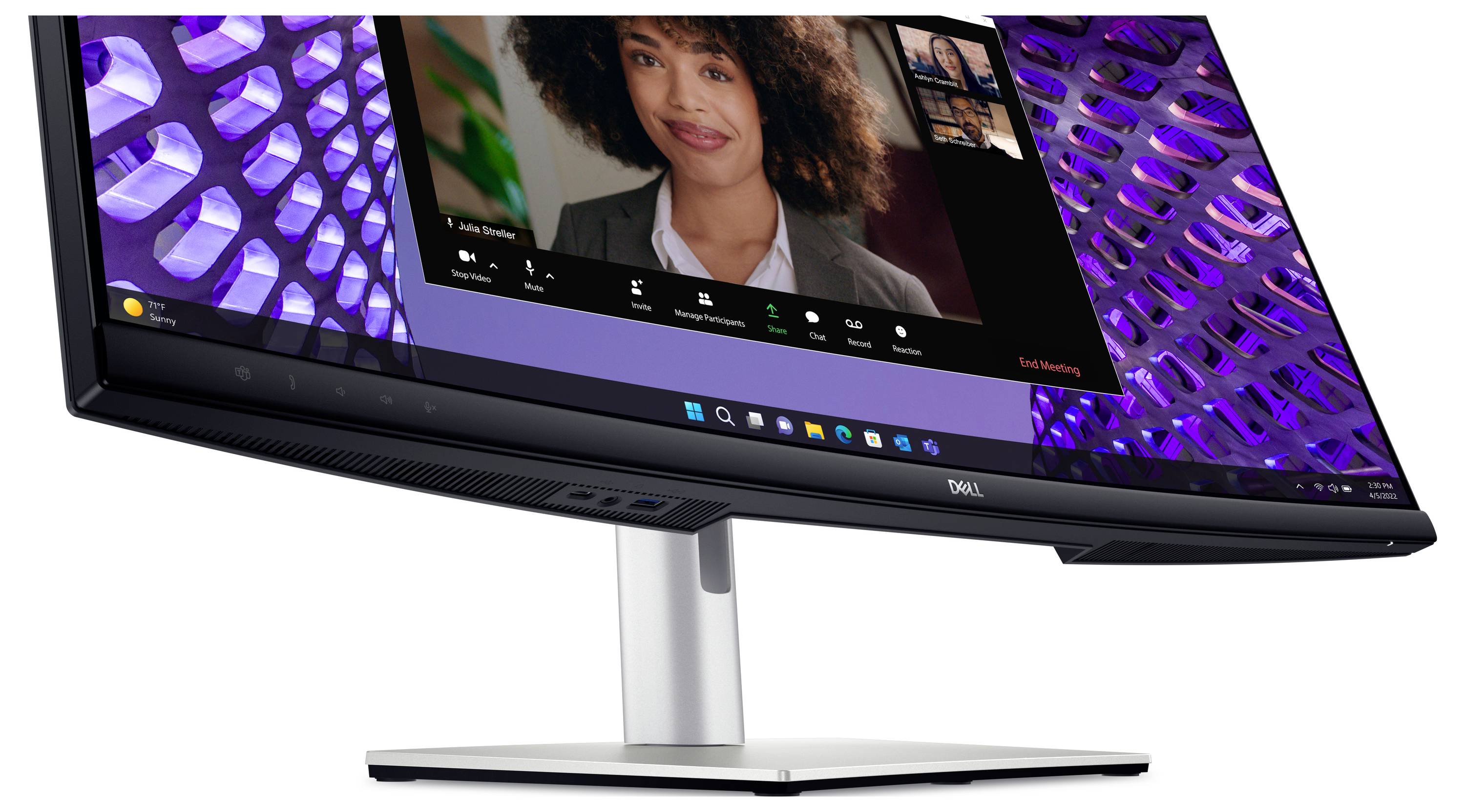 Un monitor curvo mostra una videoconferenza con più partecipanti. Una donna sta parlando, con un altro display con effetti di luce sullo sfondo.