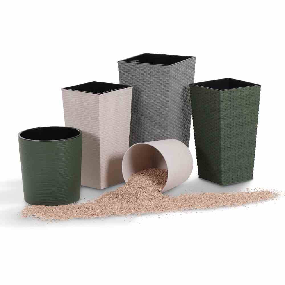 Cinque vasi di fiori diversi per dimensioni e colori, uno è posizionato di lato e sono sparse alcune palline di granulato.