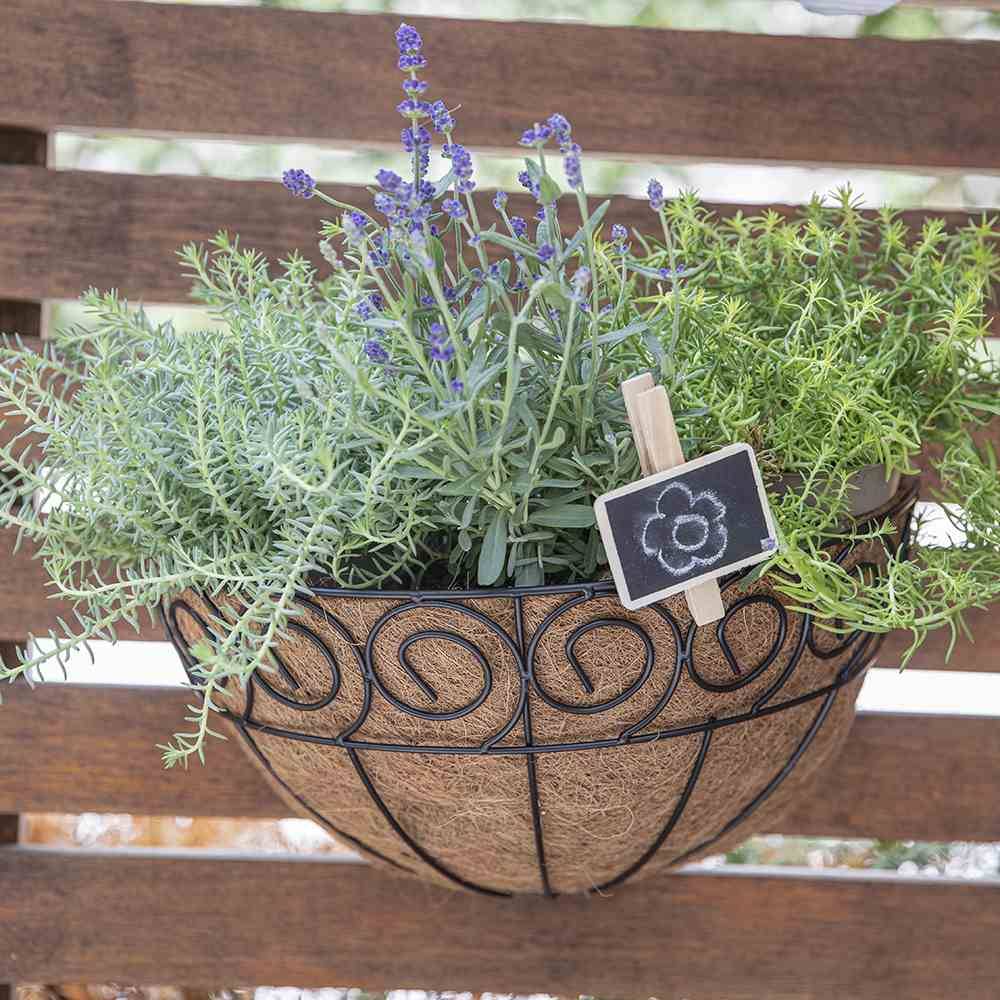 Cesto con lavanda ed erbe appeso a una parete di legno, con un piccolo cartello decorato con un fiore disegnato.