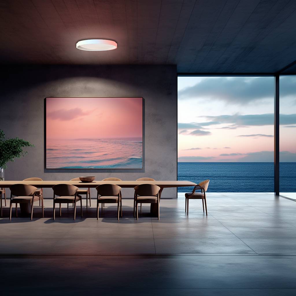 Un ambiente moderno con un lungo tavolo da pranzo e sedie. Un grande dipinto di un oceano rosa è appeso alla parete. Le finestre offrono una vista sul mare al tramonto.