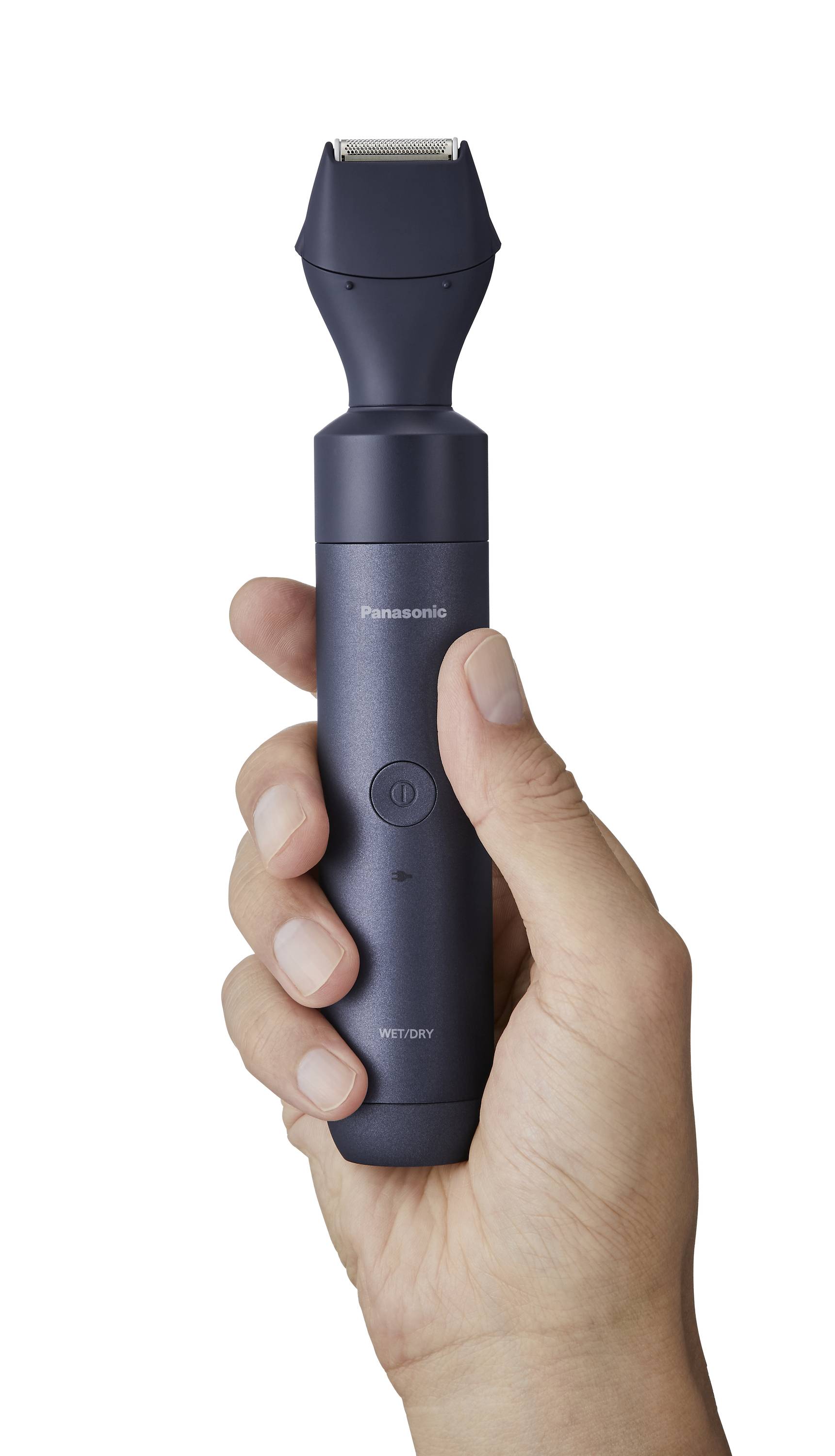 Una mano tiene un rasoio elettrico in grigio scuro. Il rasoio ha un pulsante rotondo e un dispositivo di taglio curvo.