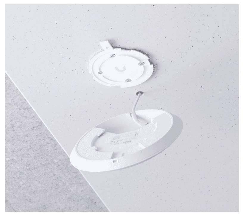 Un rilevatore di fumo rotondo bianco con il coperchio rimosso è montato su un soffitto screziato bianco, con un filo visibile che lo collega.