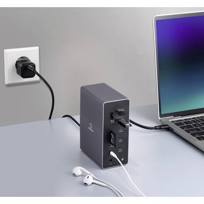 Un laptop è collegato a una stazione di aggancio connessa a una presa elettrica. Delle cuffie sono posizionate accanto.