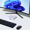 Un setup desktop con un monitor, un case compatto per computer, una tastiera e un mouse. Il monitor mostra una grafica a spirale blu.