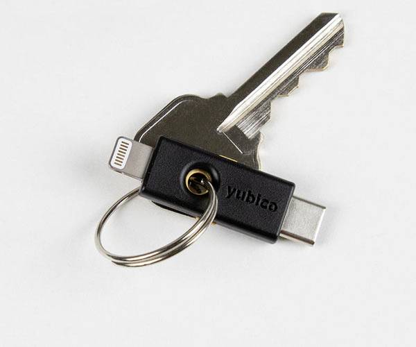 Una chiave di sicurezza USB di Yubico fissata a un portachiavi insieme a una chiave fisica.