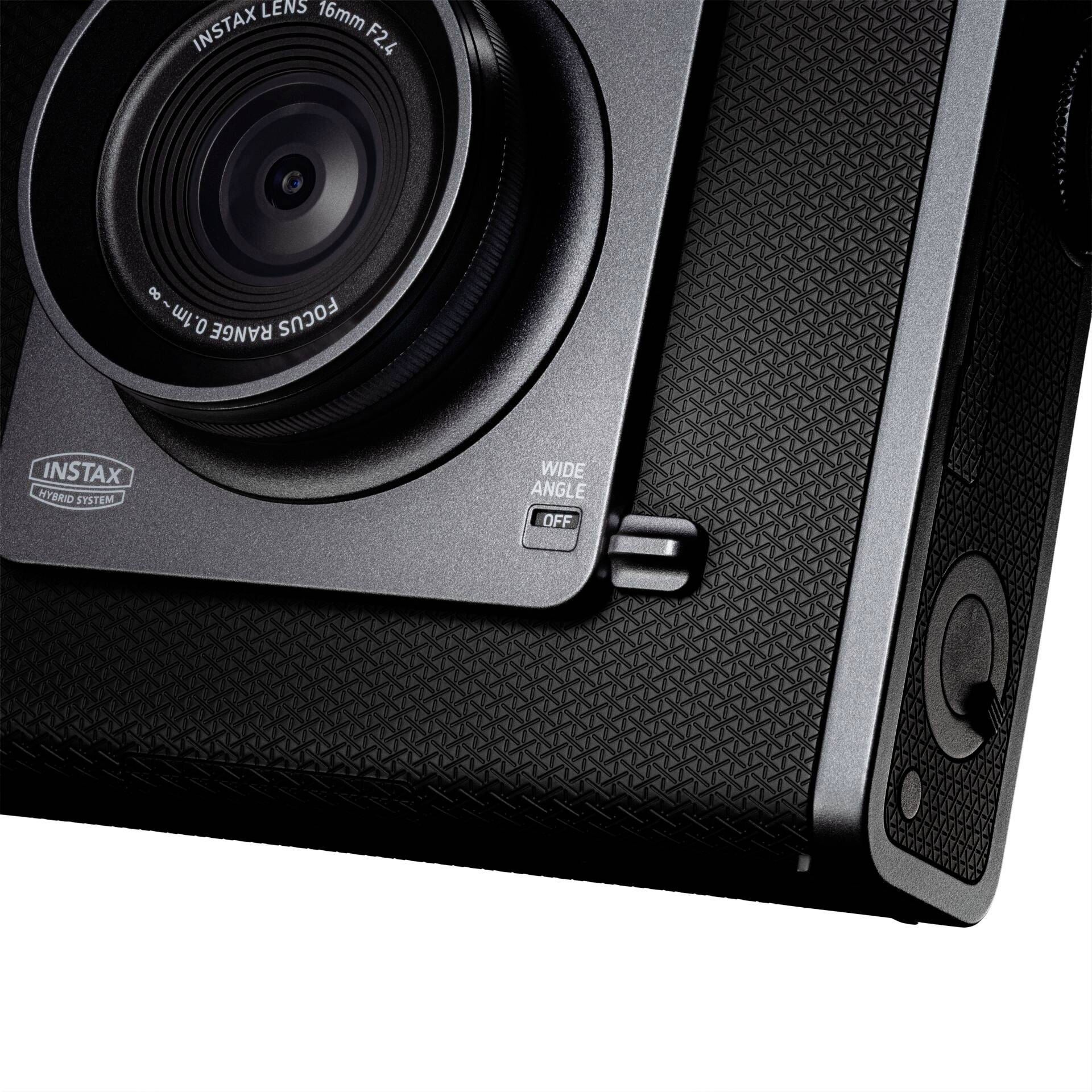 Una fotocamera istantanea nera con un obiettivo da 16mm, F2.8. La fotocamera ha una superficie strutturata e un anello di messa a fuoco.