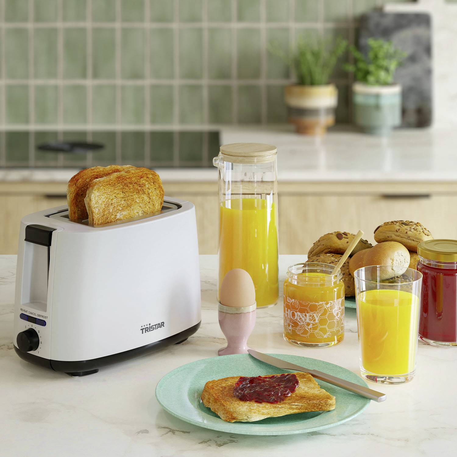 Un tostapane con due fette di pane tostato. Sul tavolo ci sono succo d'arancia, un uovo per la colazione, marmellata e miele. Una scena accogliente di cucina.