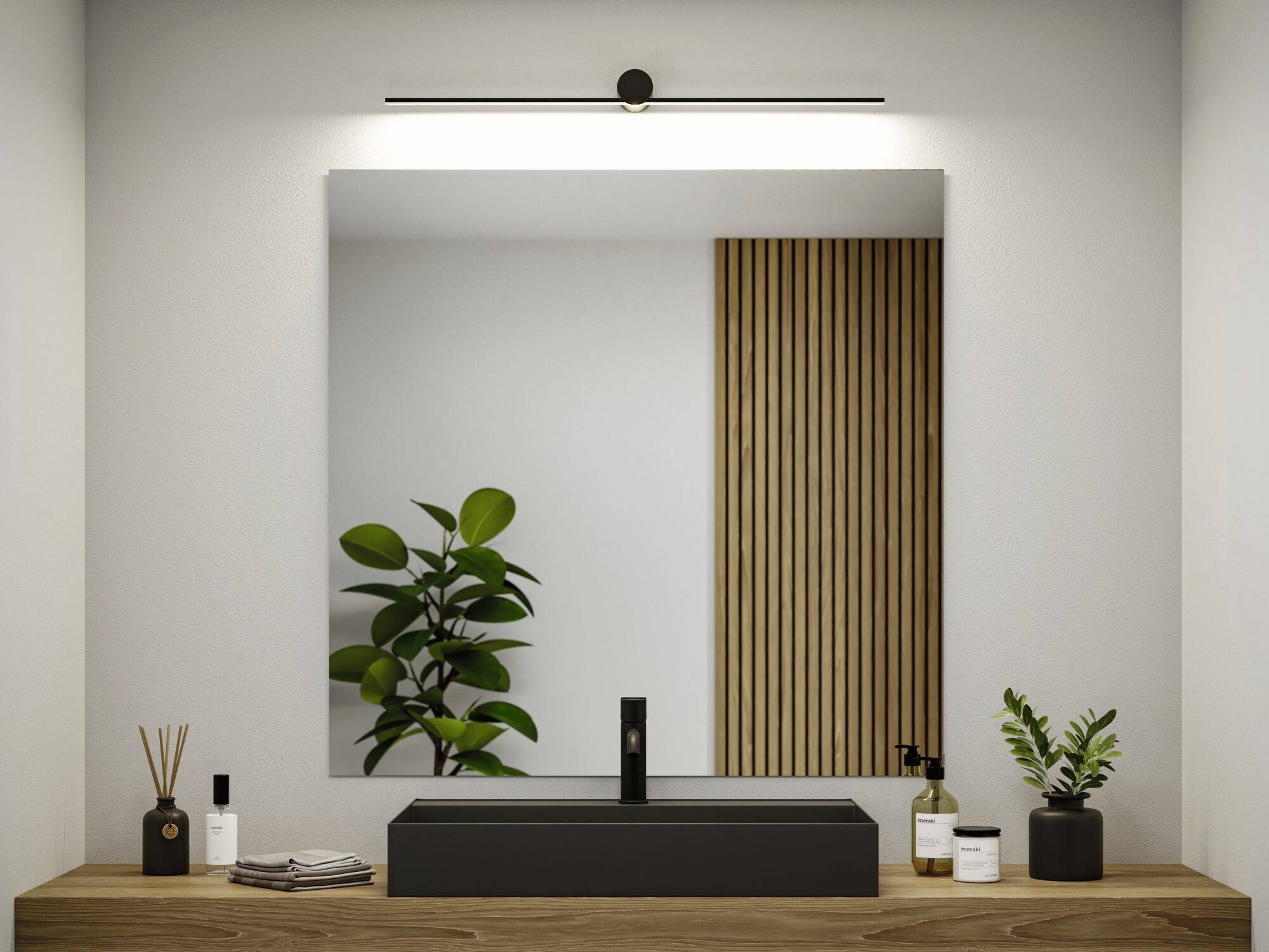 Un bagno moderno con specchio rettangolare, lavandino nero e piante su un mobile sottolavabo in legno.