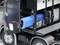 Camion con copertura laterale aperta, che mostra componenti interni inclusa una grande batteria blu e cablaggi.