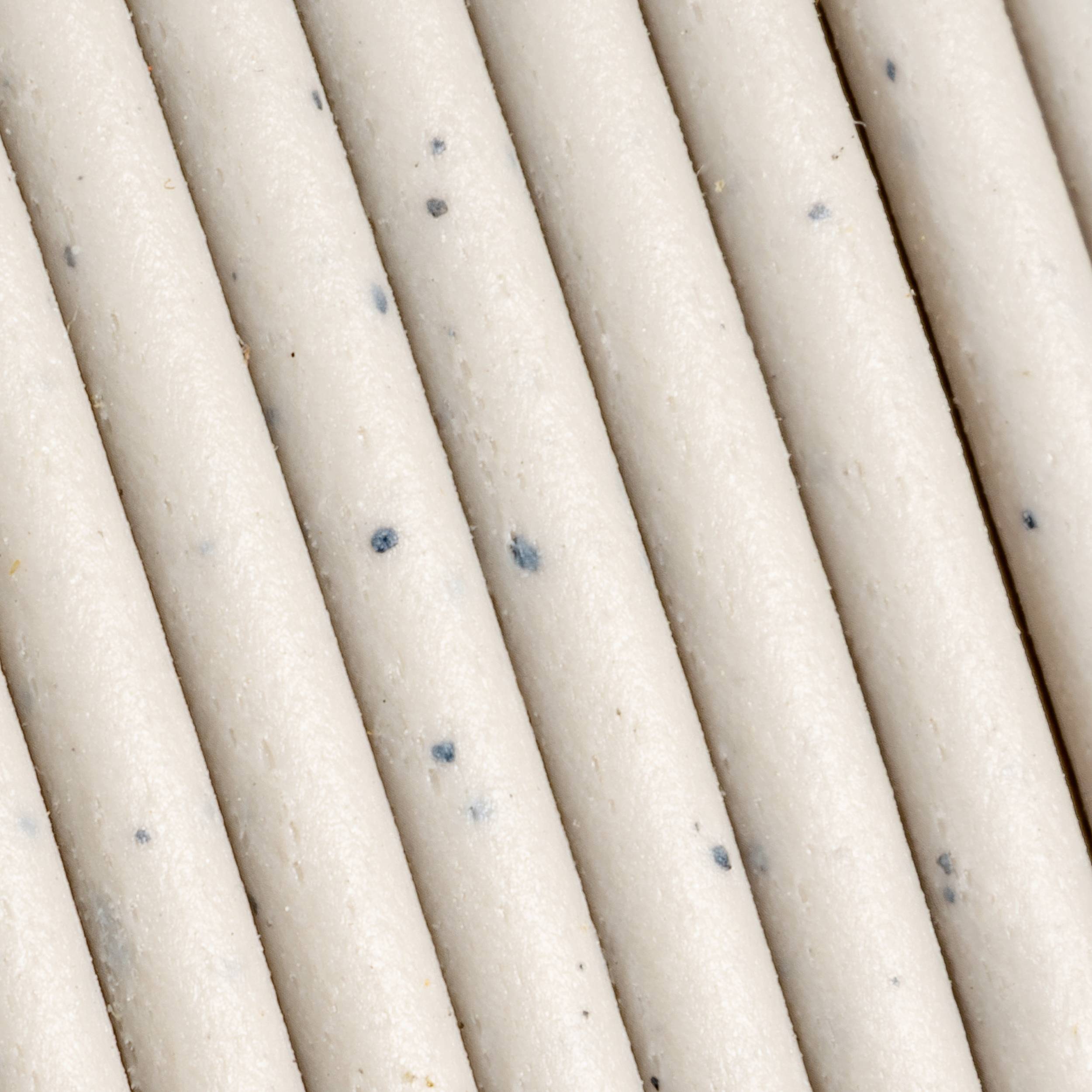 Primo piano di diverse strisce tessili bianco-grigie che corrono parallele con punti scuri.