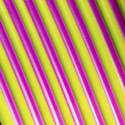 Primo piano di diverse cannucce di plastica rosa e gialle disposte in modo alternato.