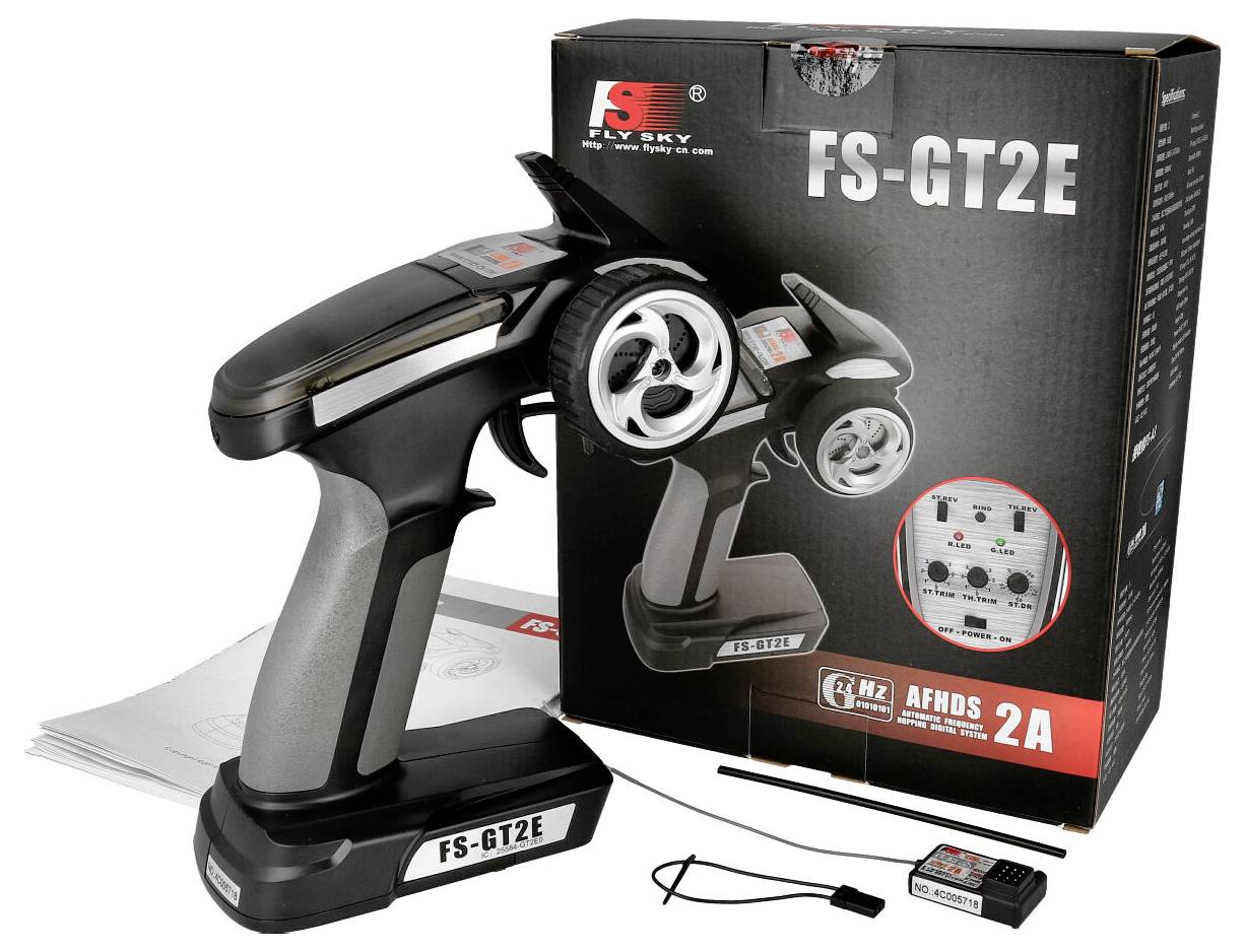 Un telecomando nero FS-GT2E con controllo di sterzo e velocità per veicoli radiocomandati, accanto alla confezione originale.