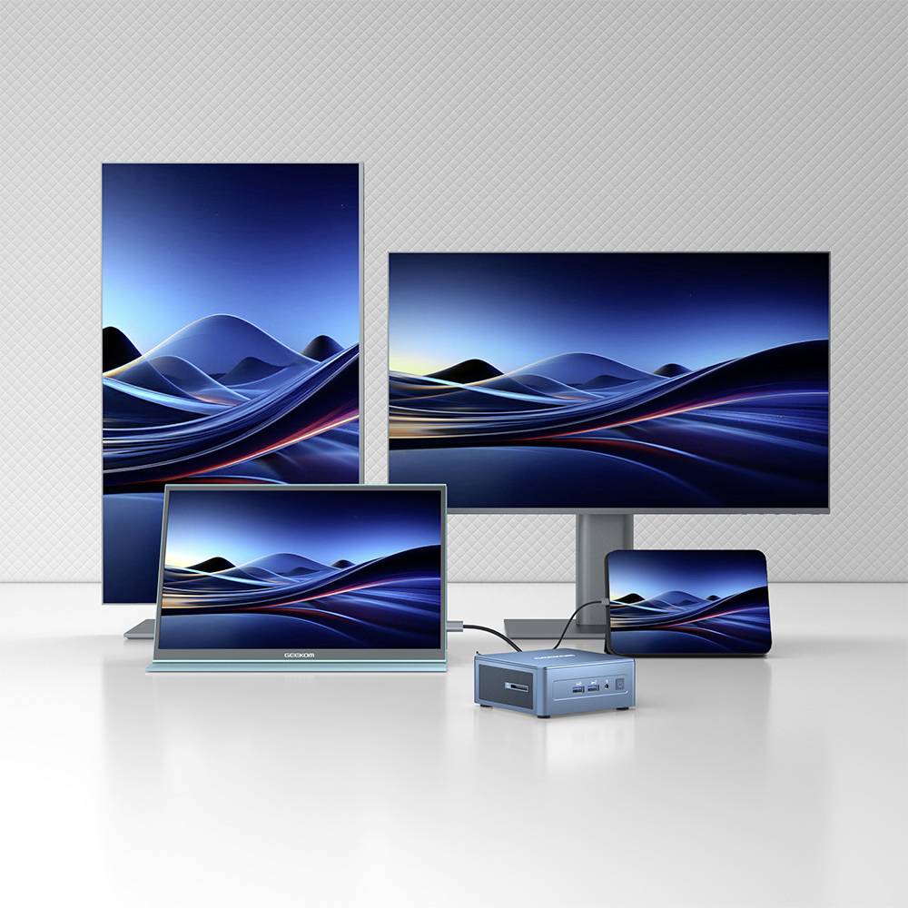 Diversi schermi e un mini PC su un tavolo, tutti mostrano la stessa immagine di onde blu sui loro display.