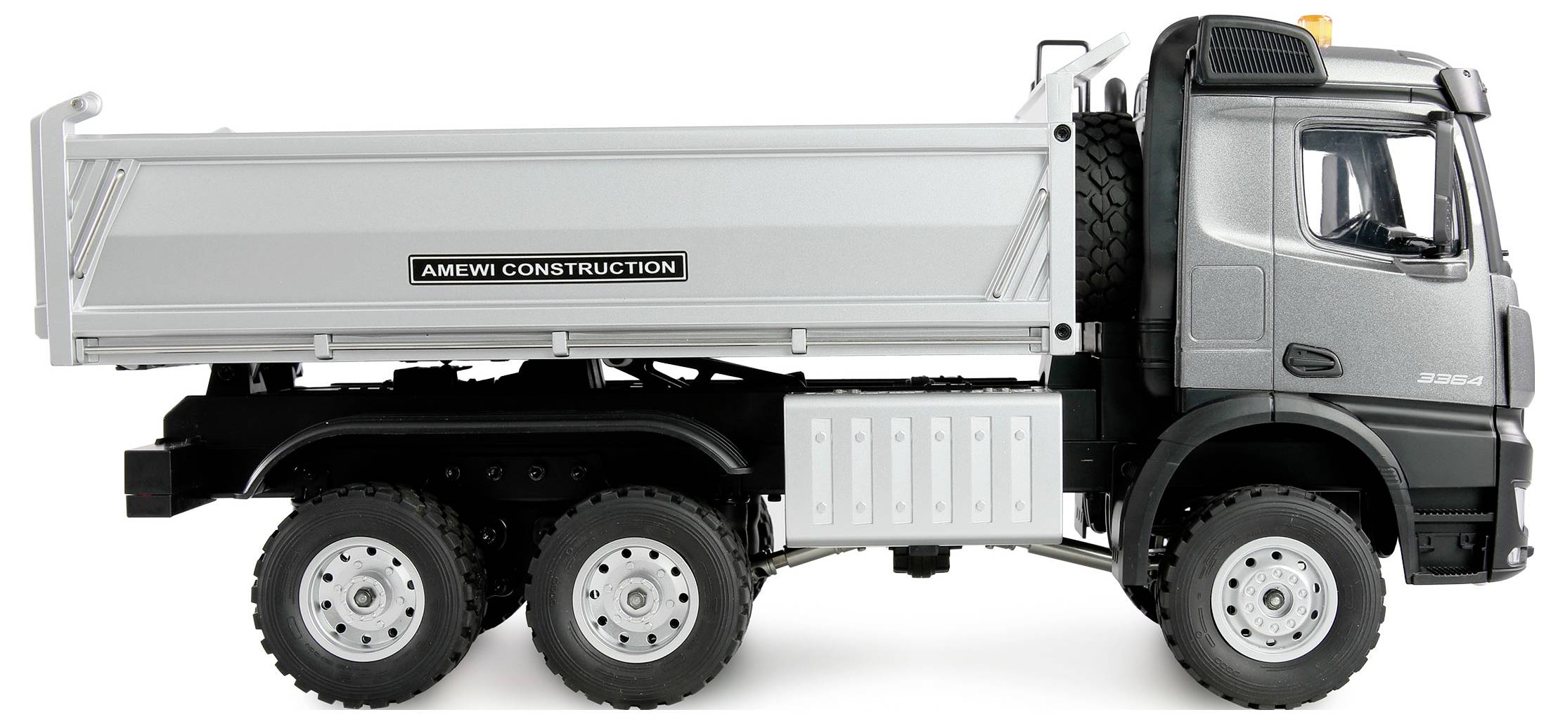 Camion argentato con cassone ribaltabile e scritta 'Amewi Construction' sul lato, parcheggiato su sfondo bianco.