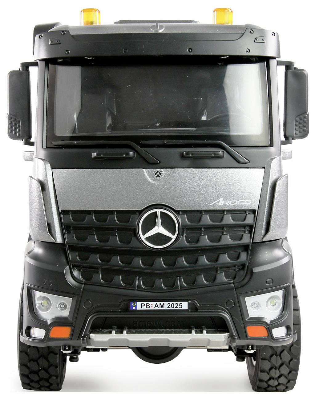 Un camion Mercedes-Benz, modello Arocs, color argento, ripreso frontalmente, con luci di avvertimento arancioni sul tetto.
