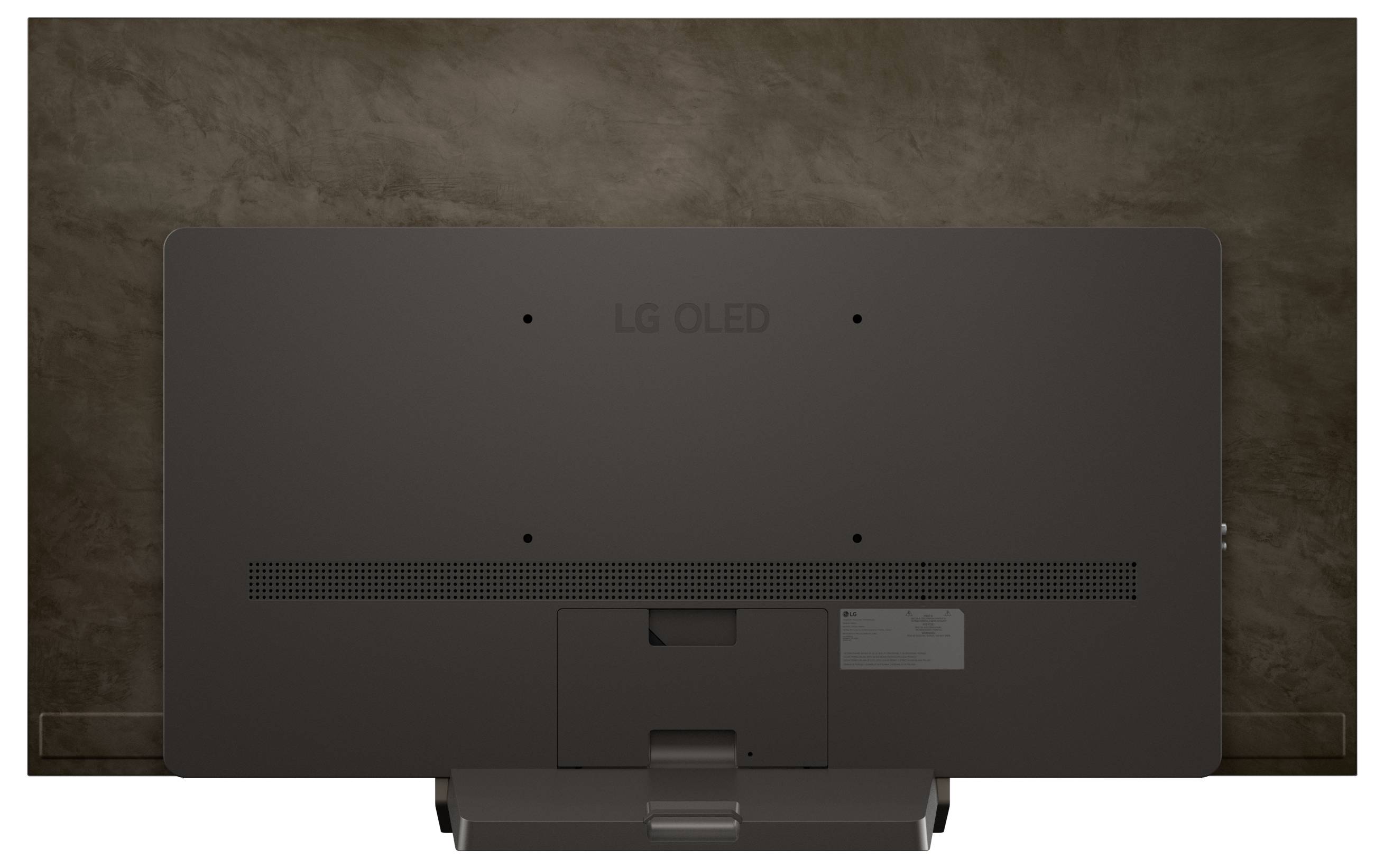 Vista posteriore di un televisore LG OLED di colore scuro contro una parete marrone dalla texture irregolare, che mostra le ventole e il supporto di montaggio con un design minimalista.